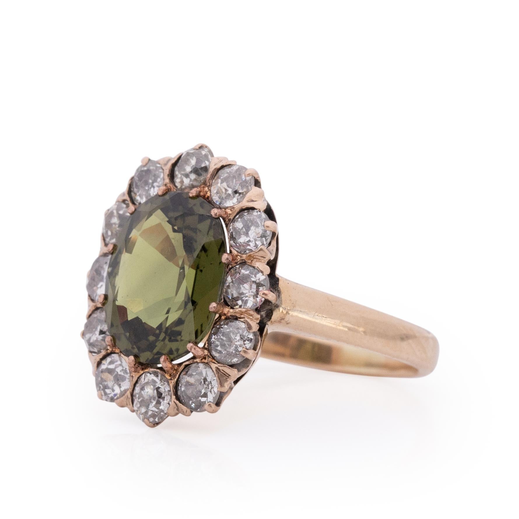 The Edwardian era is known for its  femininity and flowing lines, with a abundance of glitz and glam. This ring takes the cake! A breathtaking 3.63Ct oval brilliant cut moss/olive green sapphire sits in the center of a old mine cut diamond halo that