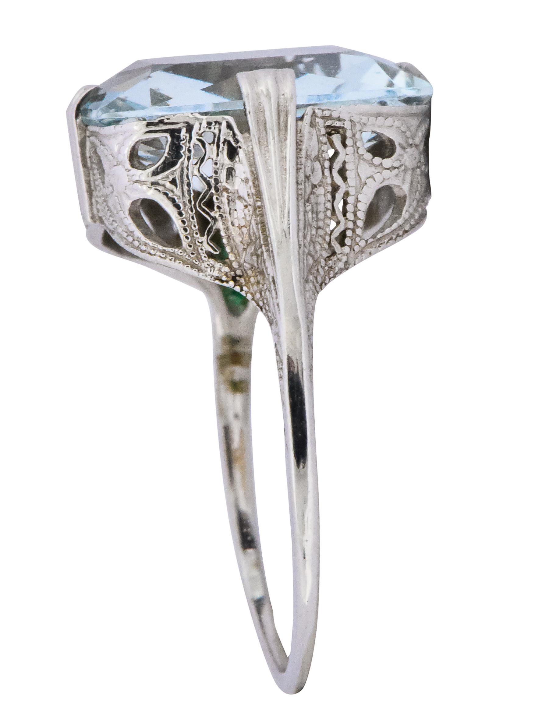 Centering a rectangular scissor cut aquamarine weighing approximately 4.00 carats

The aquamarine is a lovely light very slight greenish blue color

In a North, East, South and West style setting

With a beautiful pierced and millegrain