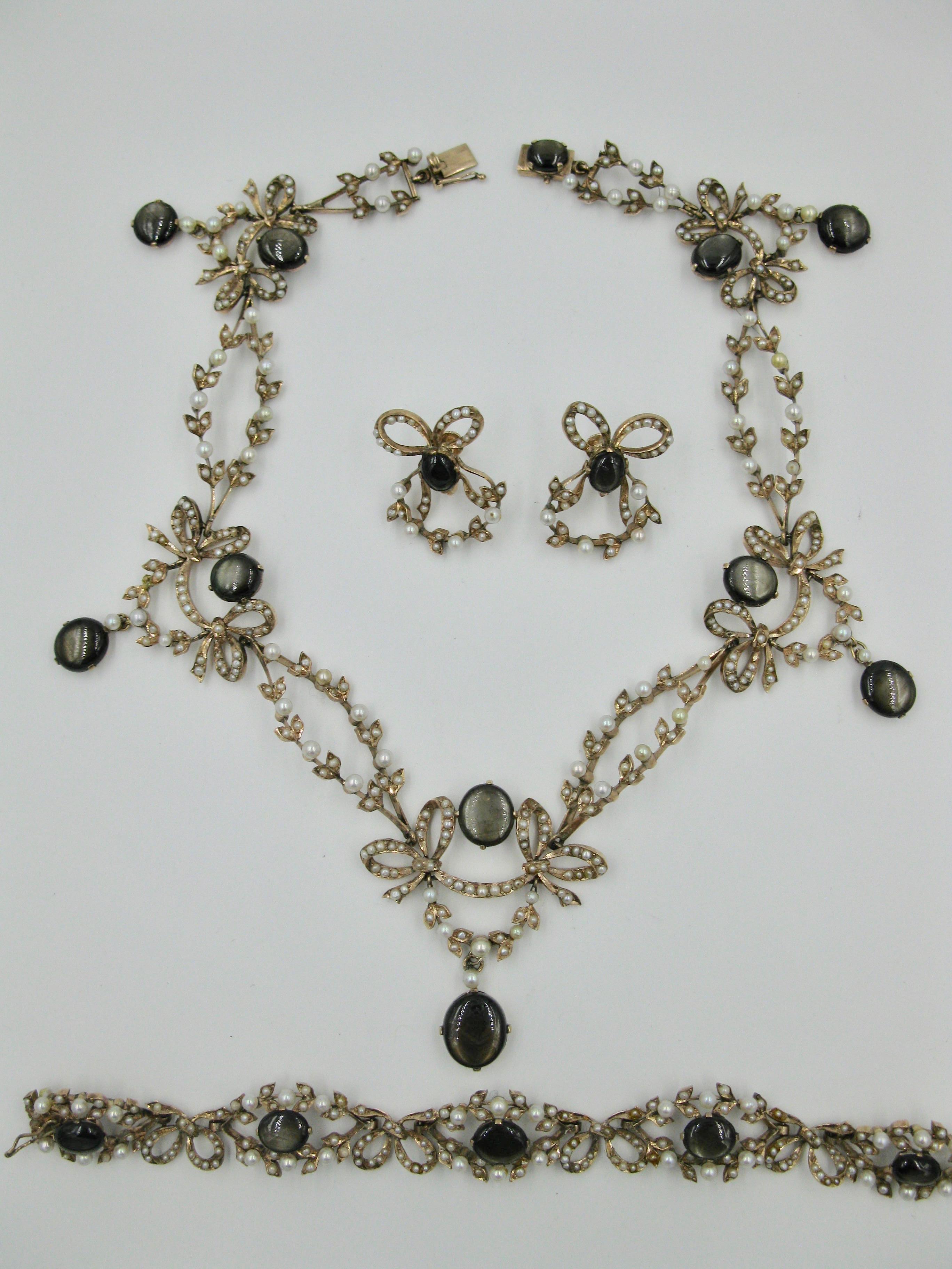 This is a spectacular museum quality antique Edwardian 43 Carat Black Star Sapphire and Seed Pearl Garland Suite.   The suite comprising a necklace, bracelet and earrings each with black star sapphires, which total approximately 43 Carat total