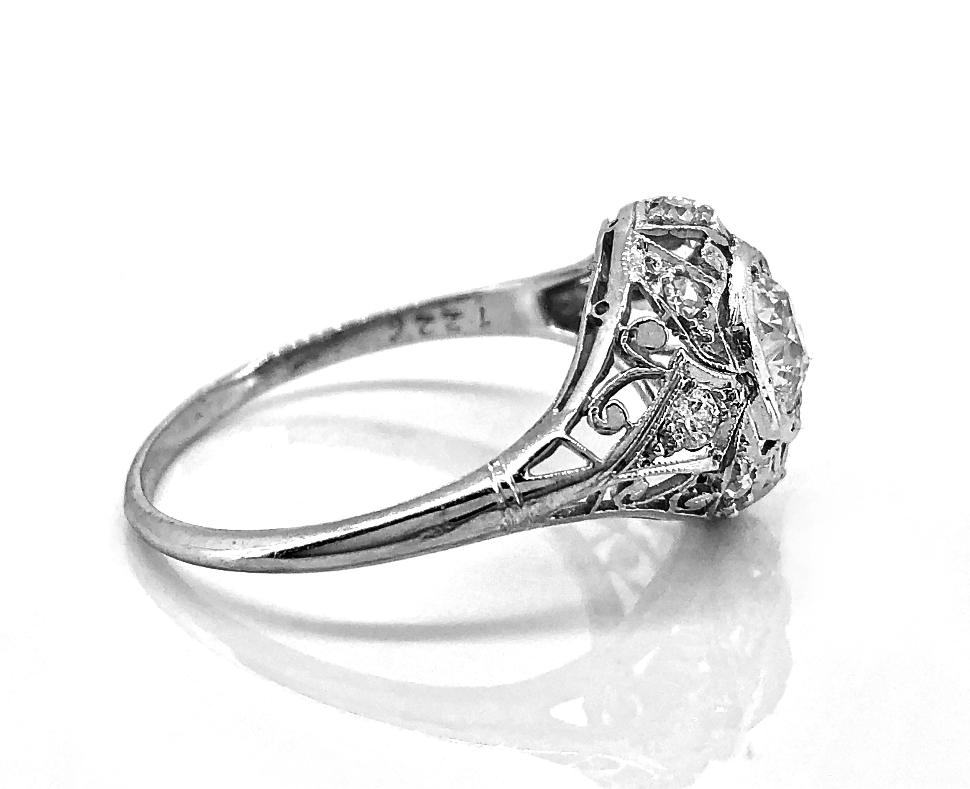 An artfully designed Edwardian diamond Antique engagement ring featuring a beautiful European cut diamond weighing .60ct. Apx. with VVS2 clarity and I color. The mounting is extraordinarily crafted in platinum with meticulous filigree and .33ct.