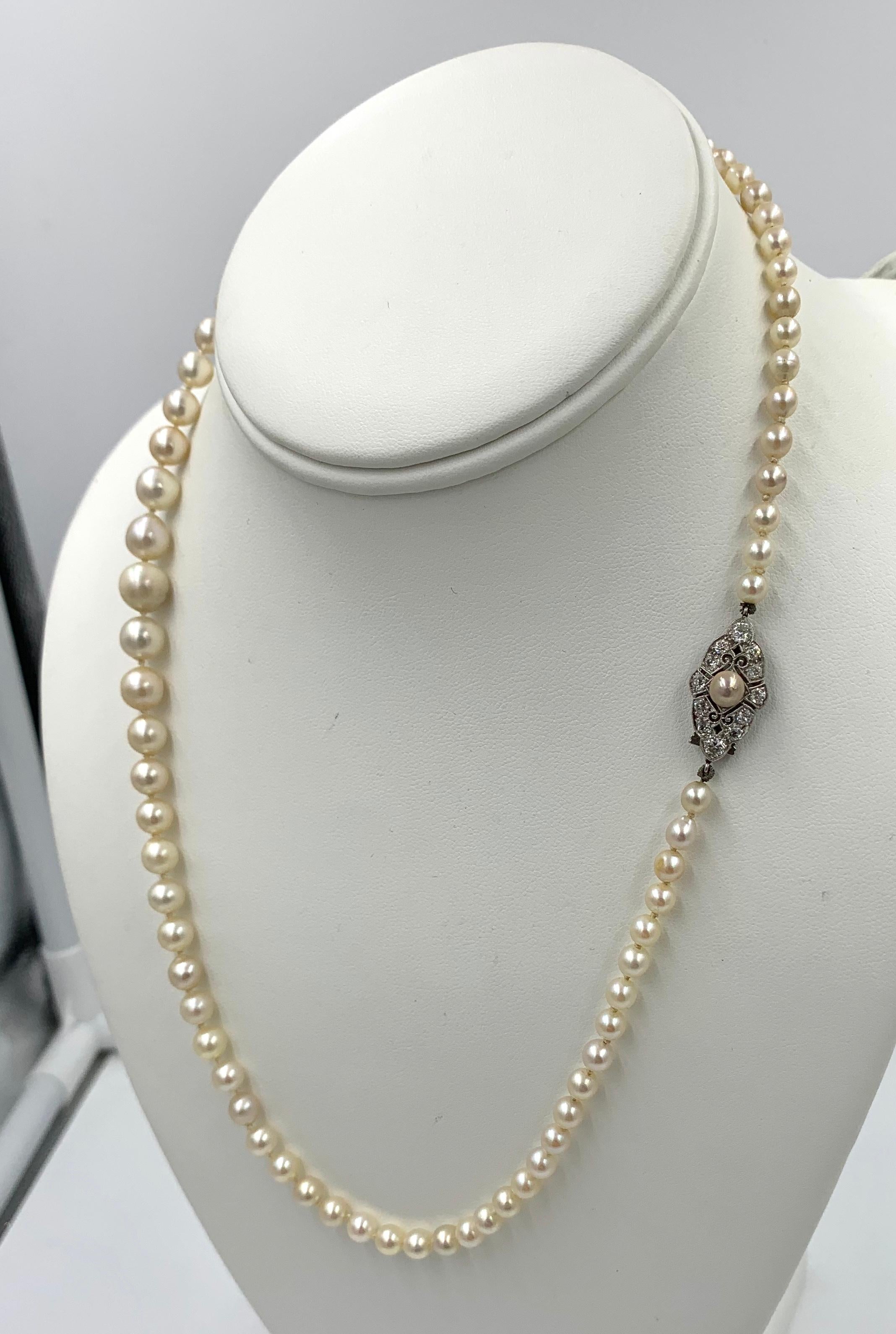An extraordinary Edwardian - Victorian Graduated Pearl Necklace with 12 Old European Cut Diamonds totaling .7 Carat.  The brilliantly white diamonds are set with a gorgeous pearl in a romantic open work clasp in Platinum.  The Pearls are cultured
