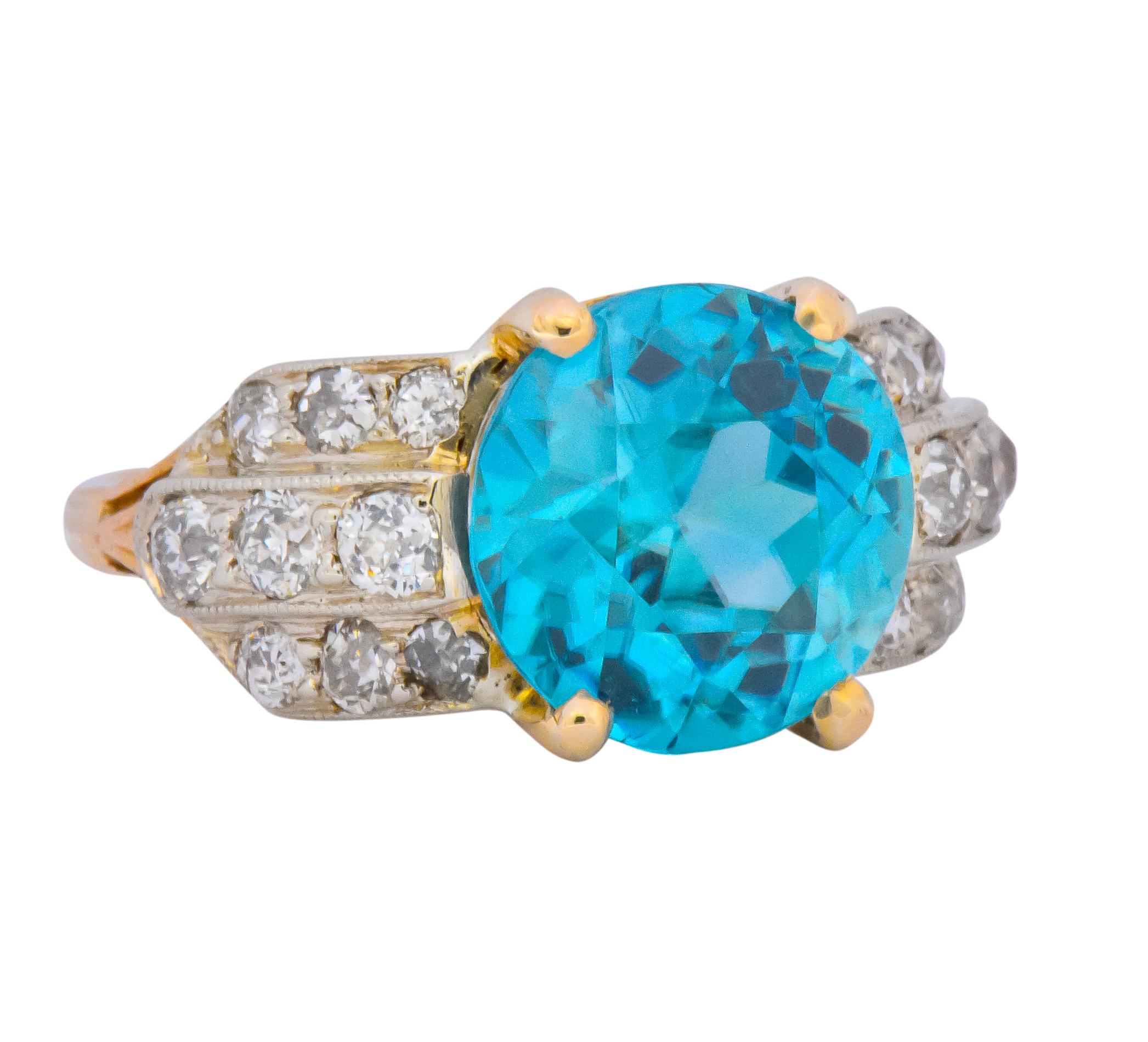Centering a round cut zircon weighing 7.83 carats, bright vibrant blue

Flanked on both sides by old European cut diamonds, weighing approximately 0.95 carat total, G to J color and VS to SI clarity 

Zircon in a four prong yellow gold head with the