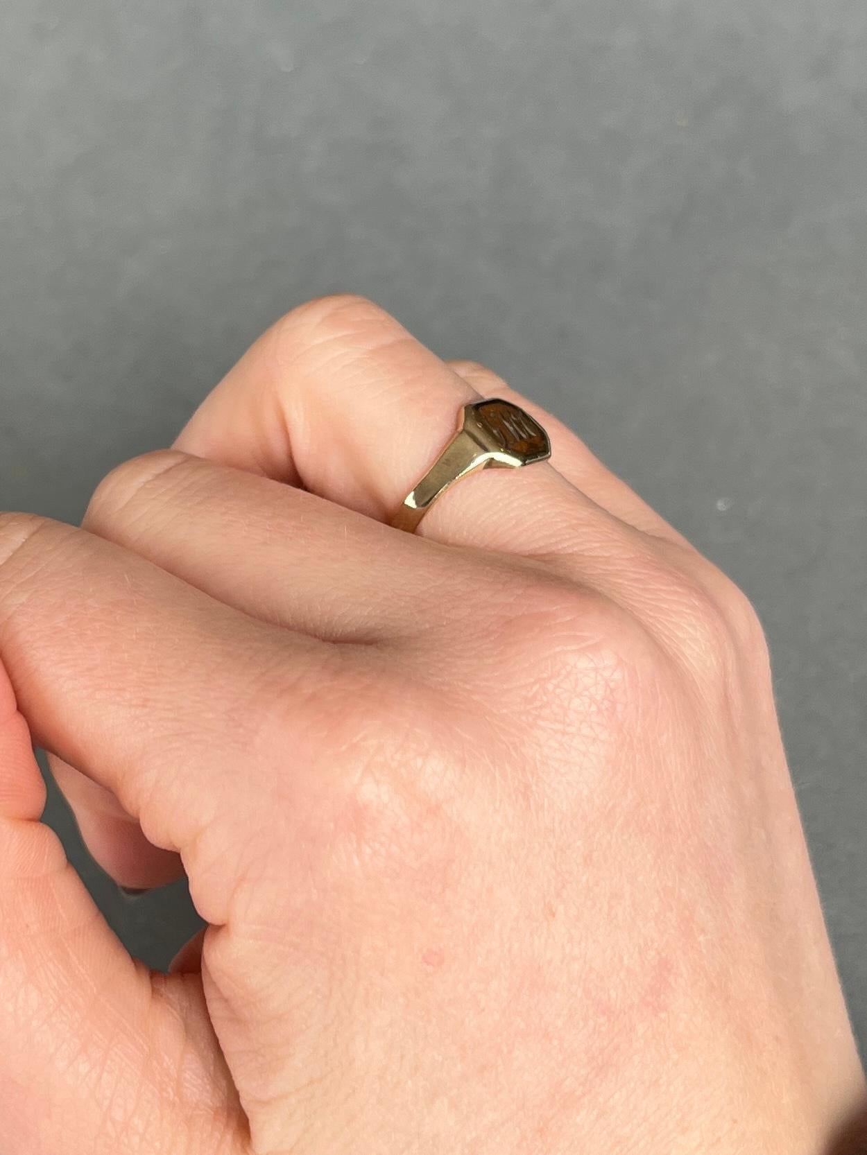 Dieser Ring ist aus glänzendem 9-karätigem Gold gefertigt und hat eine Gravur auf der Vorderseite. Die Buchstaben lauten 