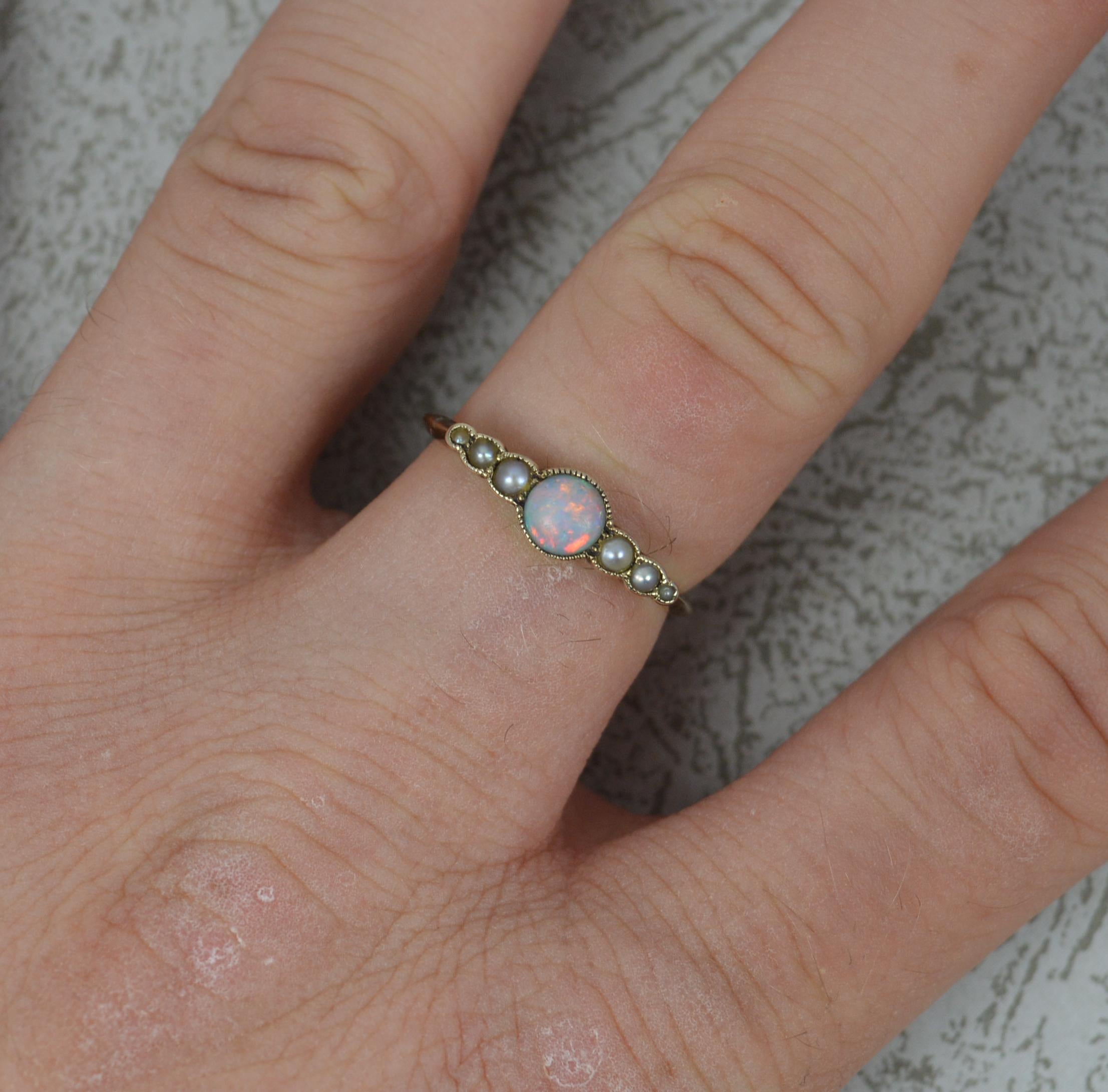 A late Victorian ring. c1900.
Solid 9 carat rose gold example. Set with a natural round opal to centre with three small seed pearls to each side.
Natural opal, flashes of all colours.
Size N 1/2 UK, 7 US. Sizeable. 1.7 Grams. 17mm spread of stones.