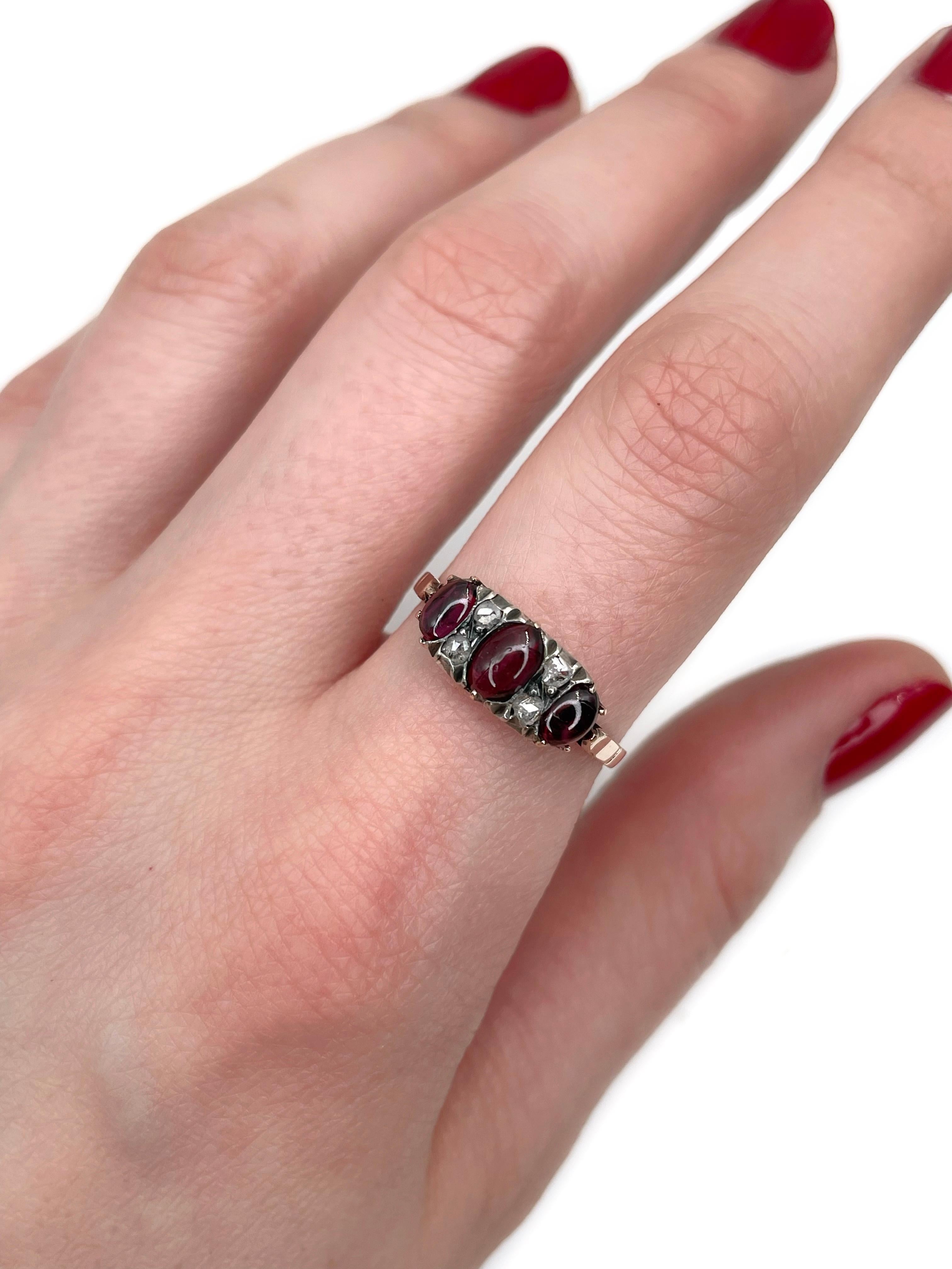 This is an Edwardian three-stone ring crafted in 9K gold. Circa 1900. 

The piece features:
- 3 garnets, oval cabochon cut
- 4 diamonds, rose cut

Weight: 2.29g
Size: 18.25 (US 8)

IMPORTANT: please ask about the possibility to resize before