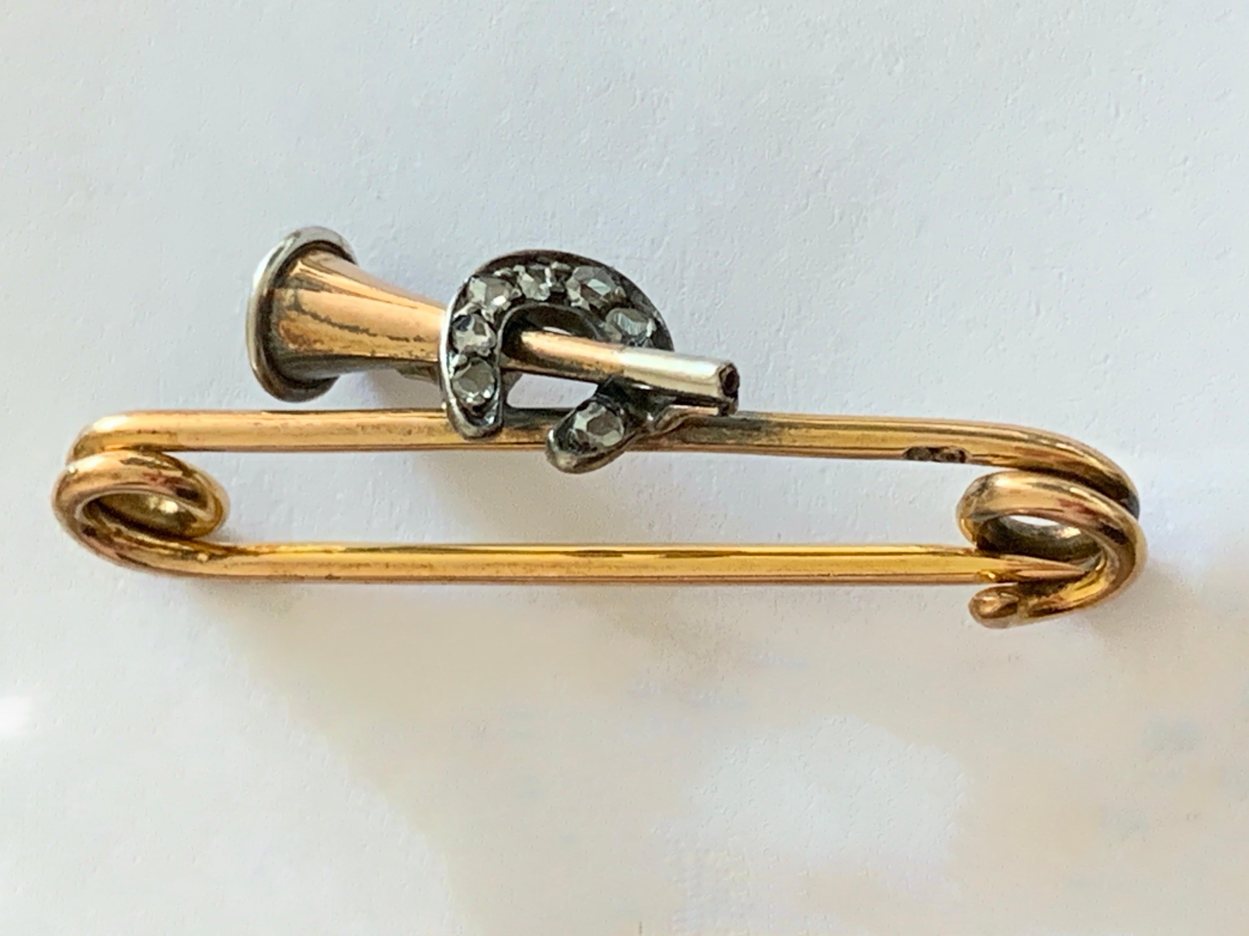 Antique Edwardian 9ct gold Equestrian 
Lucky diamond set in white gold horseshoe brooch 
that holds a feather in place in the end of the trumpet
delightful natural mine cut diamonds 
that amount to 0.20 carat each one measures 1.8mm
and there are 8