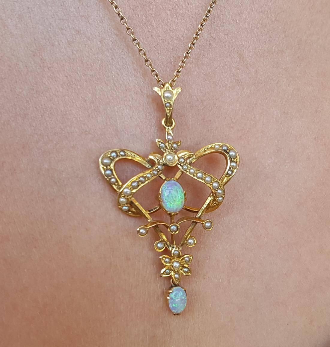 Very pretty 9ct gold art nouveau pendant featuring 2 oval opals and seed pearls in an organic floral design. The dimensions are approximately 3cm wide and 5cm long from top of bale to bottom of opal drop. Sinuous art nouveau elements in this