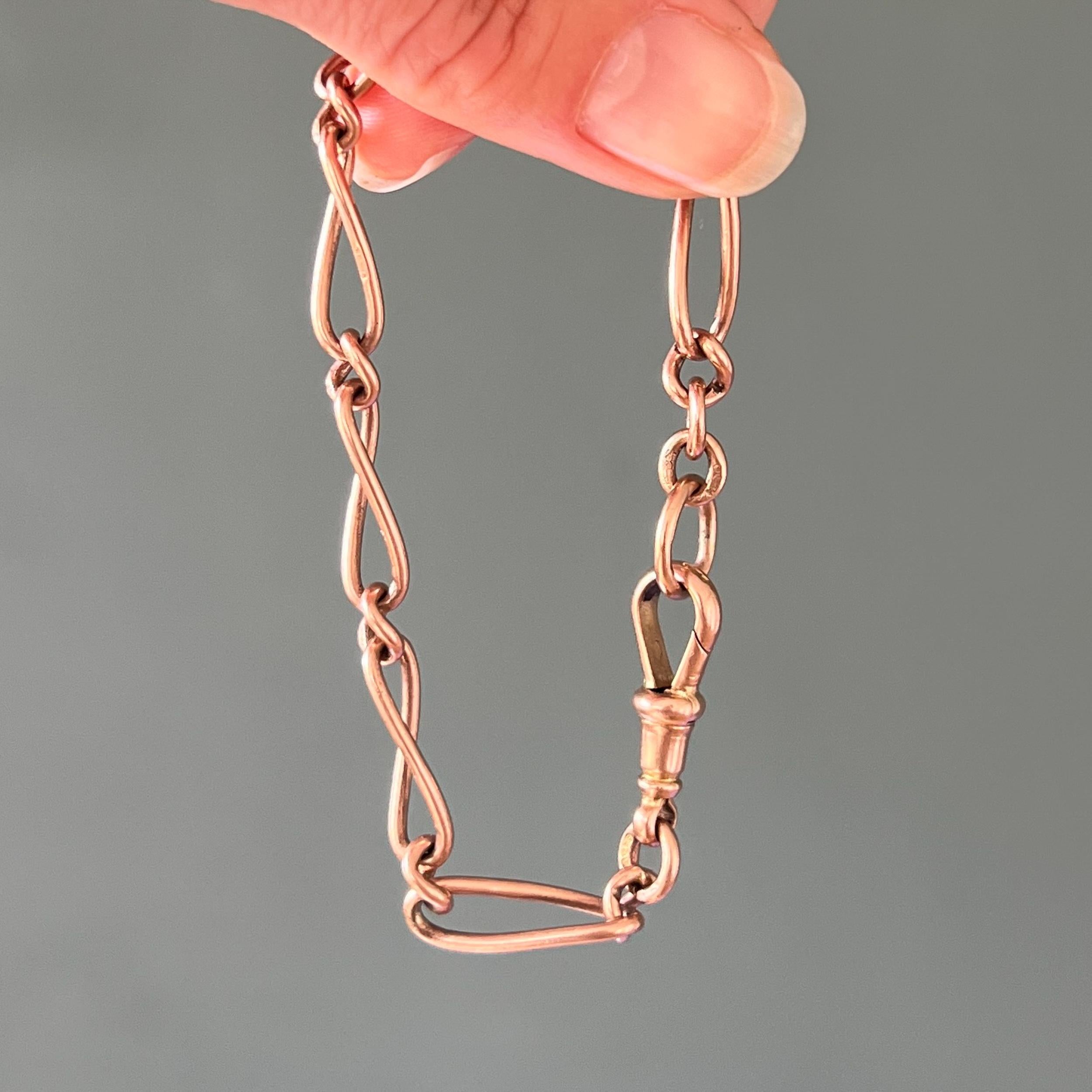 An antique Edwardian Albert chain bracelet made from solid 9 carat gold curb links that have a beautiful rose gold hue with a twisted oval design. Each link is marked 375 which stands for 9 carat gold. The chain is provided with an antique swivel