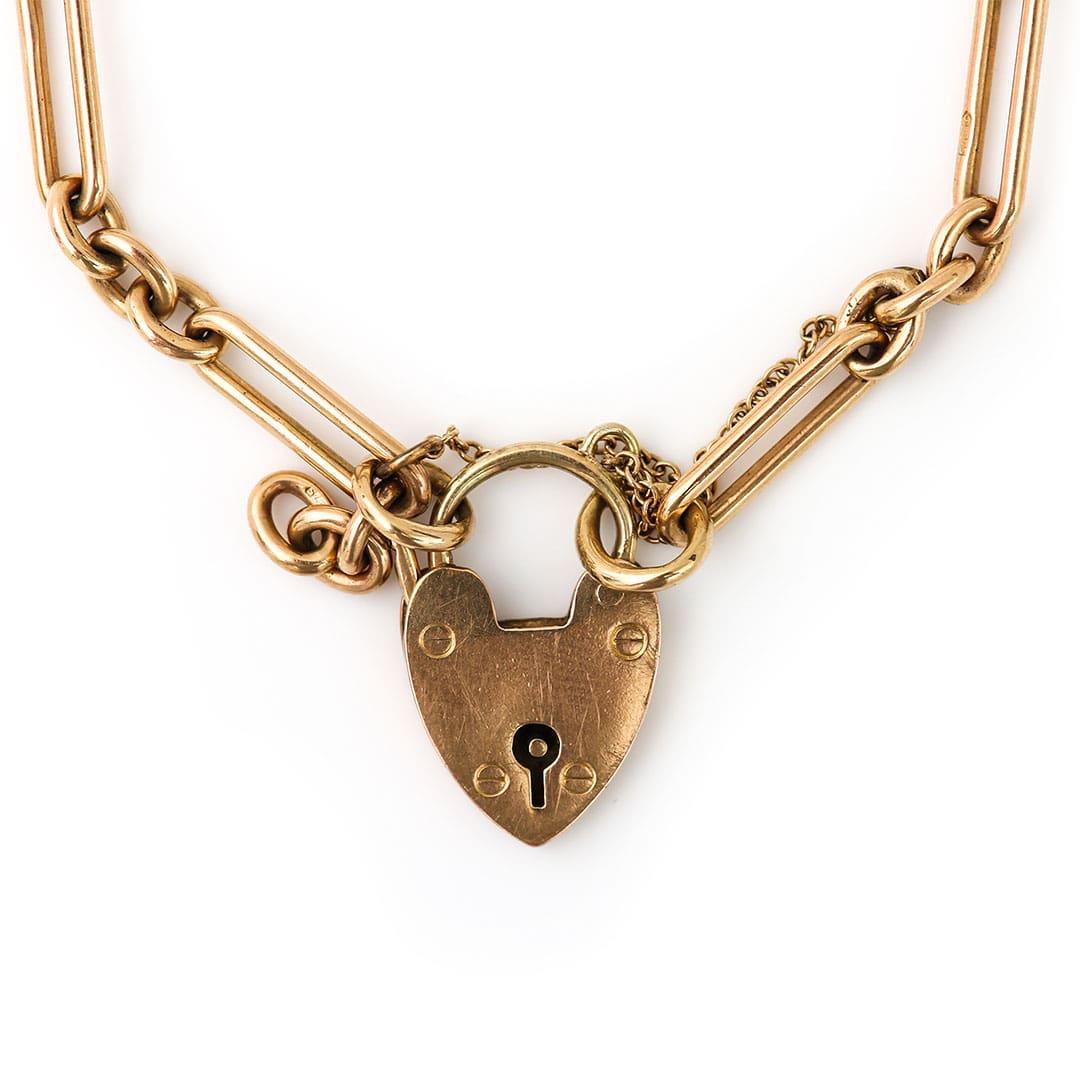 A very pretty 9ct yellow gold trombone or paper link chain bracelet with a heart padlock dating from the Edwardian era circa 1910. The single fetter or paper link measure 15mm long and are connected by three round links and are in excellent