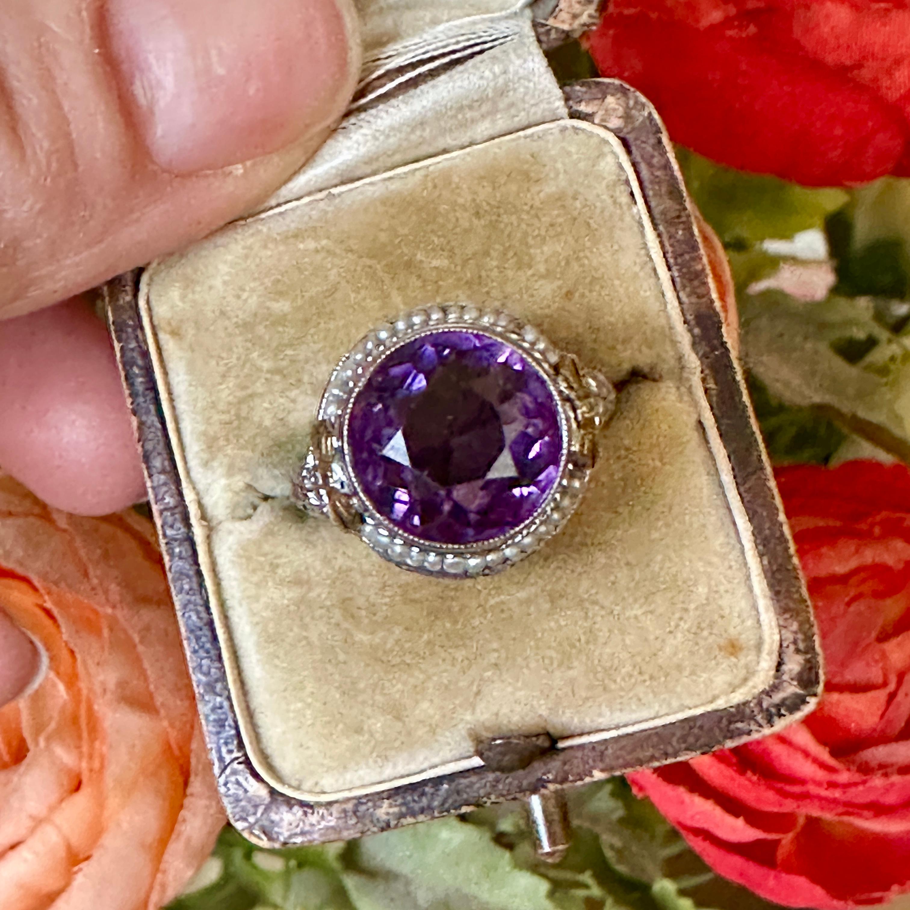 Details:
Stunning Edwardian period amethyst, seed pearl and 14K white and yellow gold filigree ring! We love the sweet bow details on the shoulders of the setting! The stone measures 11mm, and the ring is 8mm above the finger at the highest point on