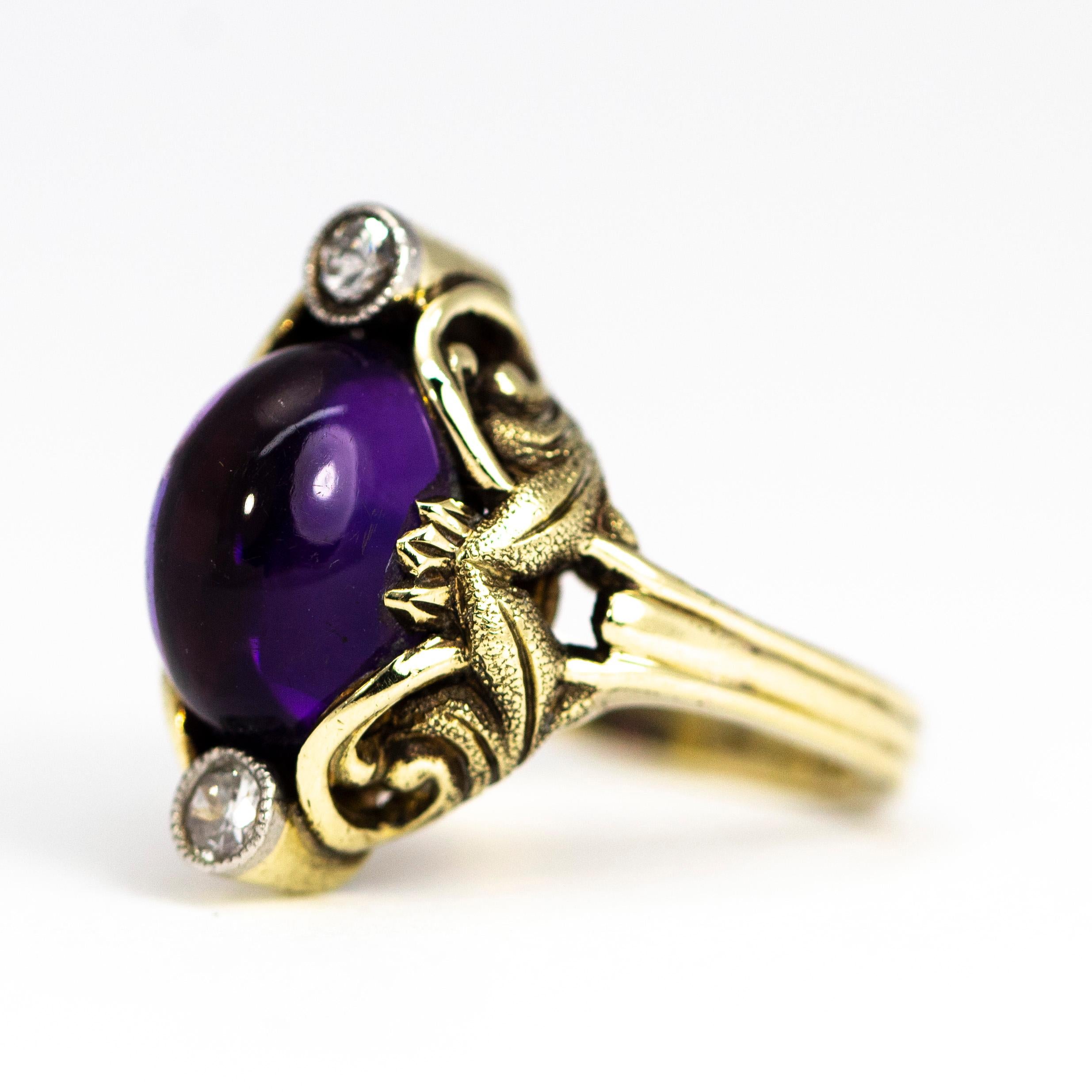 This stunning amethyst cabochon is set in a stunning 15ct gold ornate setting. Above and below the glossy stone sit two 7pt diamonds. The shoulders have scroll and leaf details. The leaves on the shoulders are finely textured and give wonderful