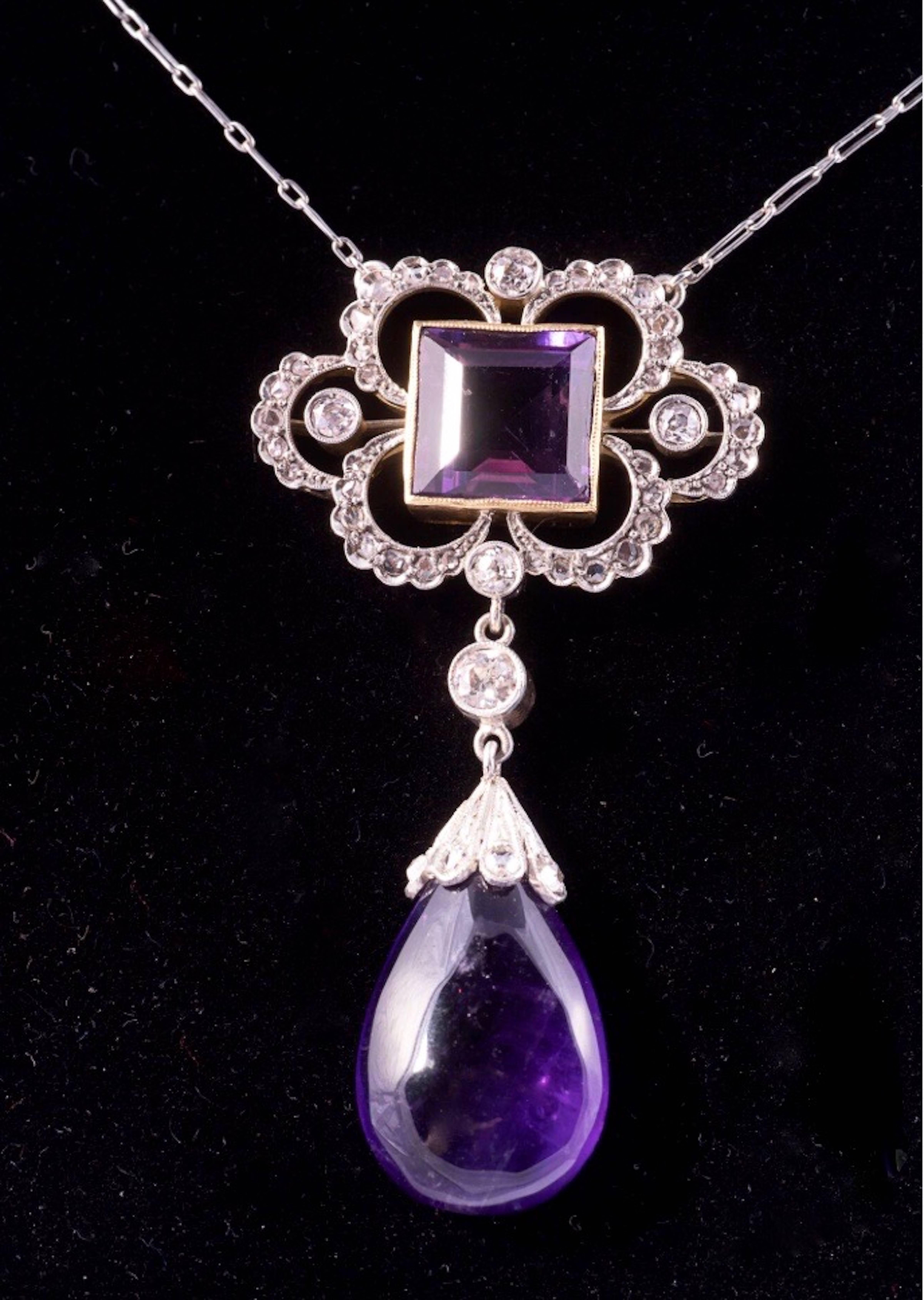 Breathtaking Edwardian Amethyst and Diamond Pendant necklace. The design features a 9.50mm square step cut amethyst and a an approximate 1 inch drop shape amethyst. There is one .20ct diamond, four .10ct diamonds and 42 smaller diamonds in the