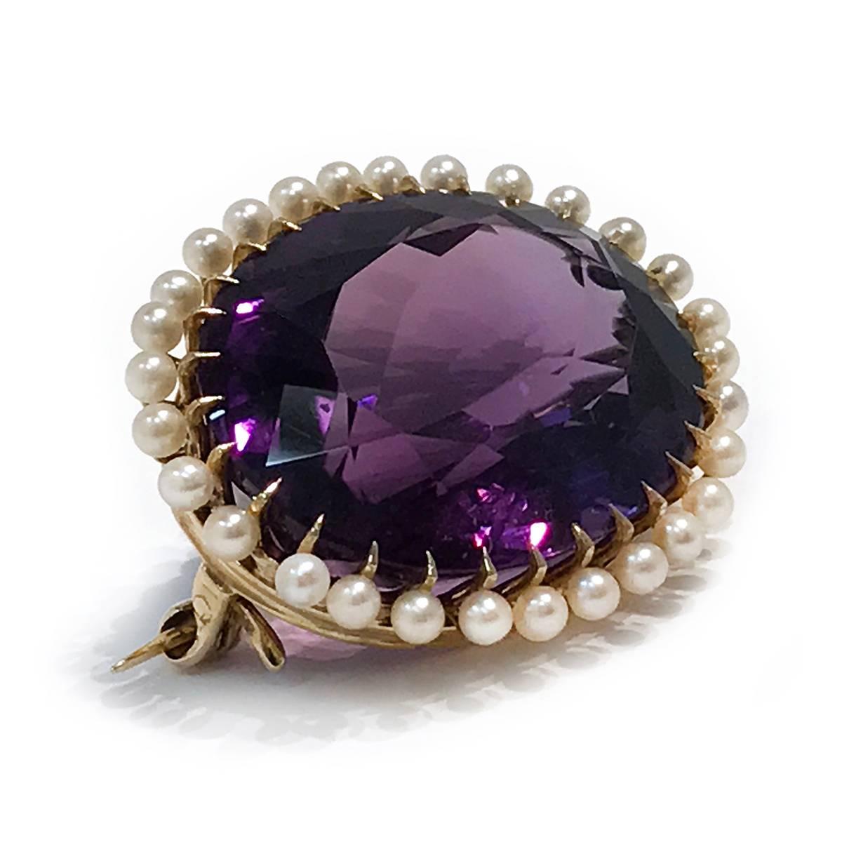 Edwardian 14 Karat Yellow Gold Amethyst and Seed Pearls Brooch. The oval-cut center Amethyst has a total carat weight of 22.97 carats, it's bezel and prong-set with twenty-nine (29) 2mm seed pearls surround. The total weight of the brooch is 9.6