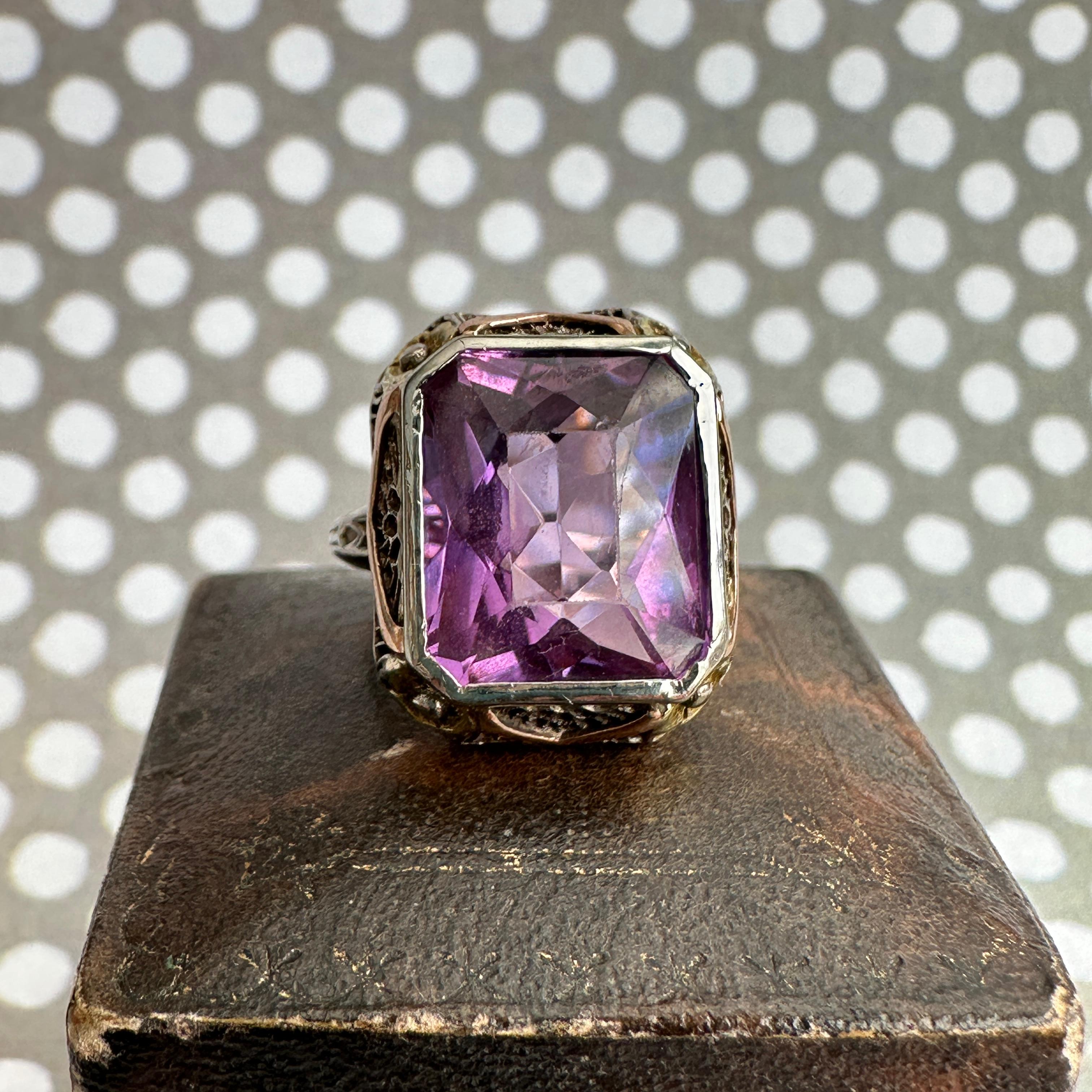 Details:
Stunning Edwardian period amethyst, 3-color gold filigree ring! The majority of the ring is 14K white gold filligree, with yellow gold pansies, and rose gold flourish details. We love the sweet pansy details on the corners of the setting!