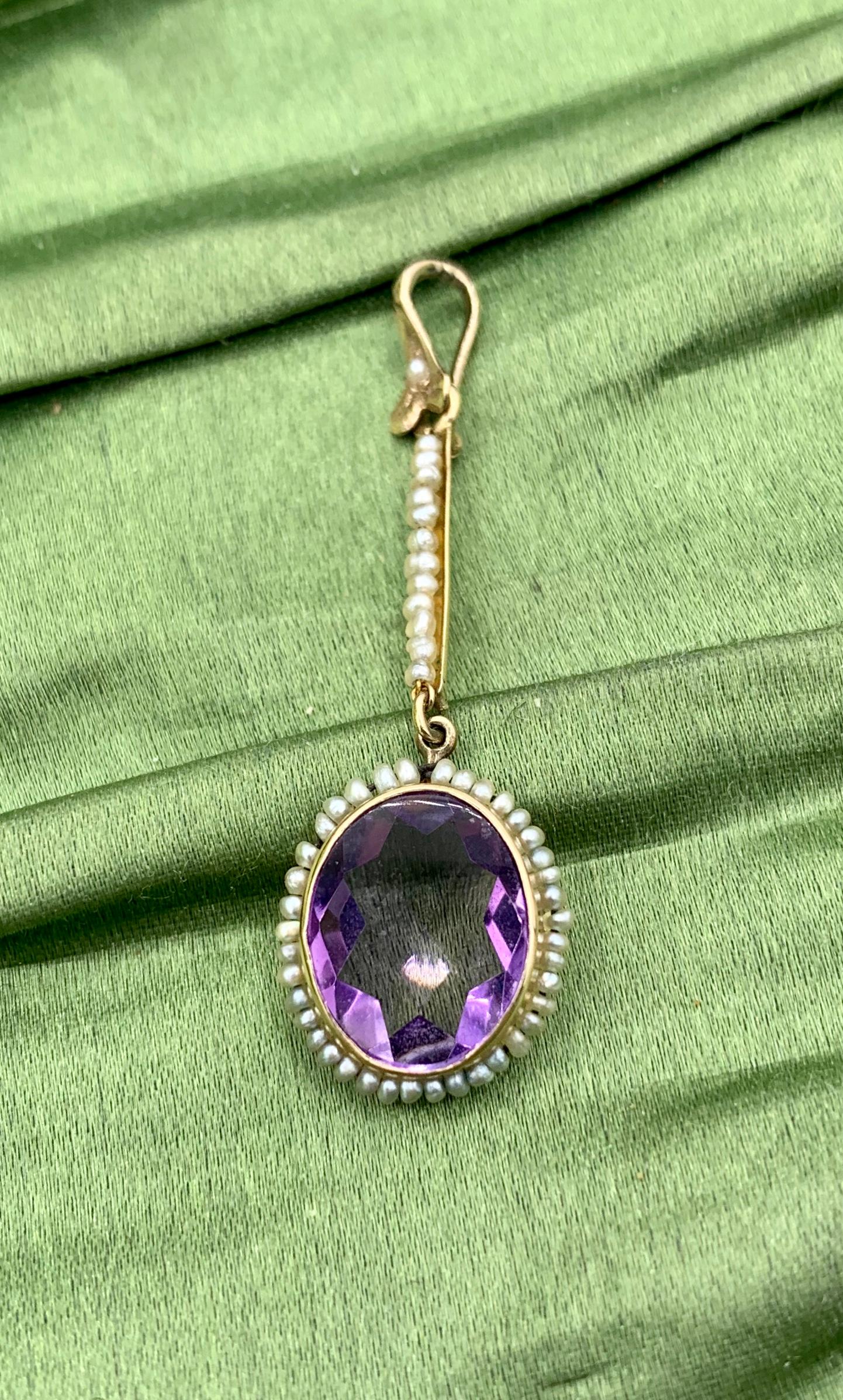 THIS IS A STUNNING EDWARDIAN AMETHYST PEARL LAVALIERE PENDANT WITH THE MOST GORGEOUS NATURAL OVAL FACETED TWO CARAT AMETHYST GEM SURROUNDED BY A HALO OF SEED PEARLS AND HANGING FROM A LONG ROW OF SEED PEARLS WITH A PEARL SET BALE.  THE LAVALIERE IS