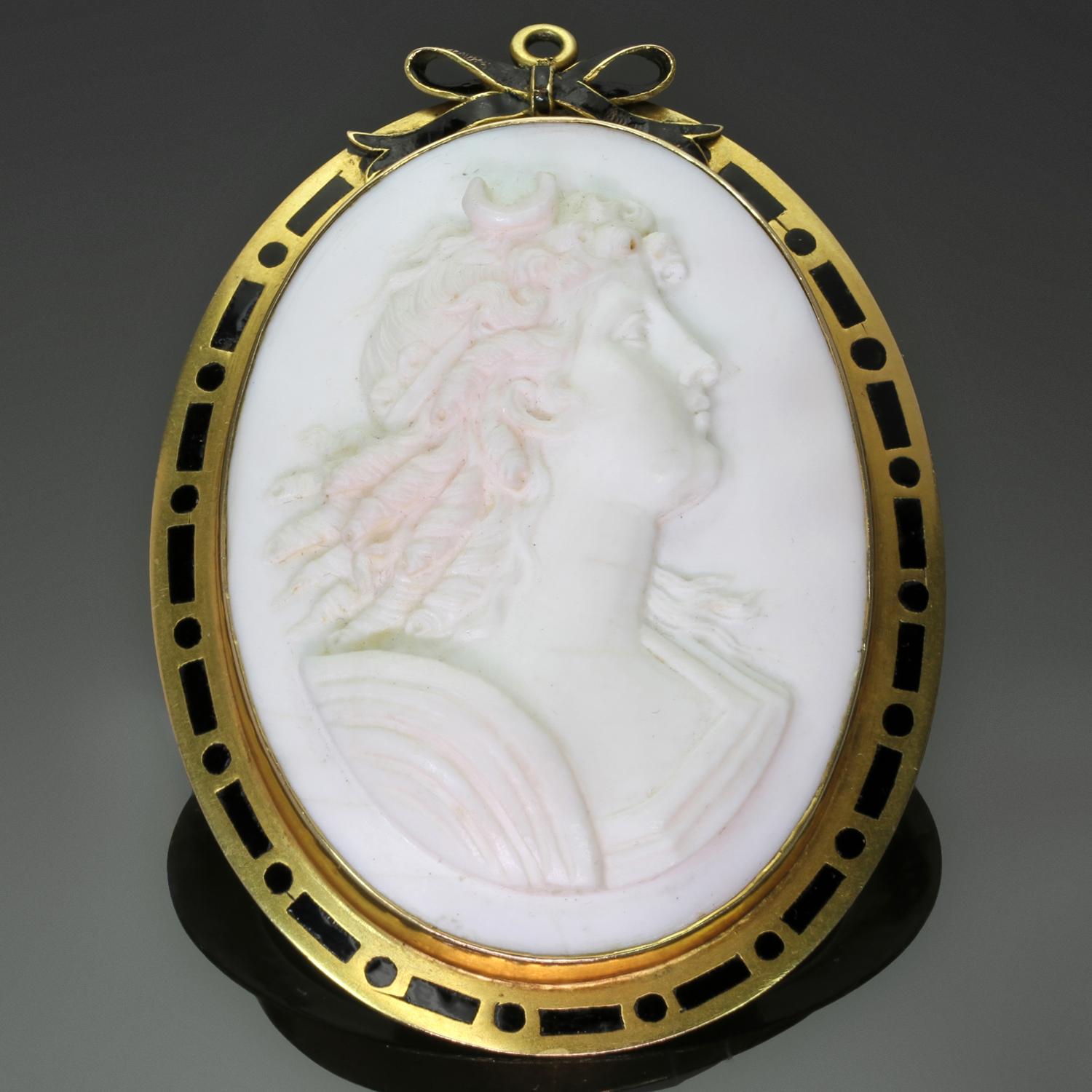 A rare hand-carved natural angel skin coral cameo brooch that can also be worn as a pendant. Framed by 14k yellow gold with black enamel designs. The carving details and the pale pink to white colors of the cameo make this pin a truly stunning