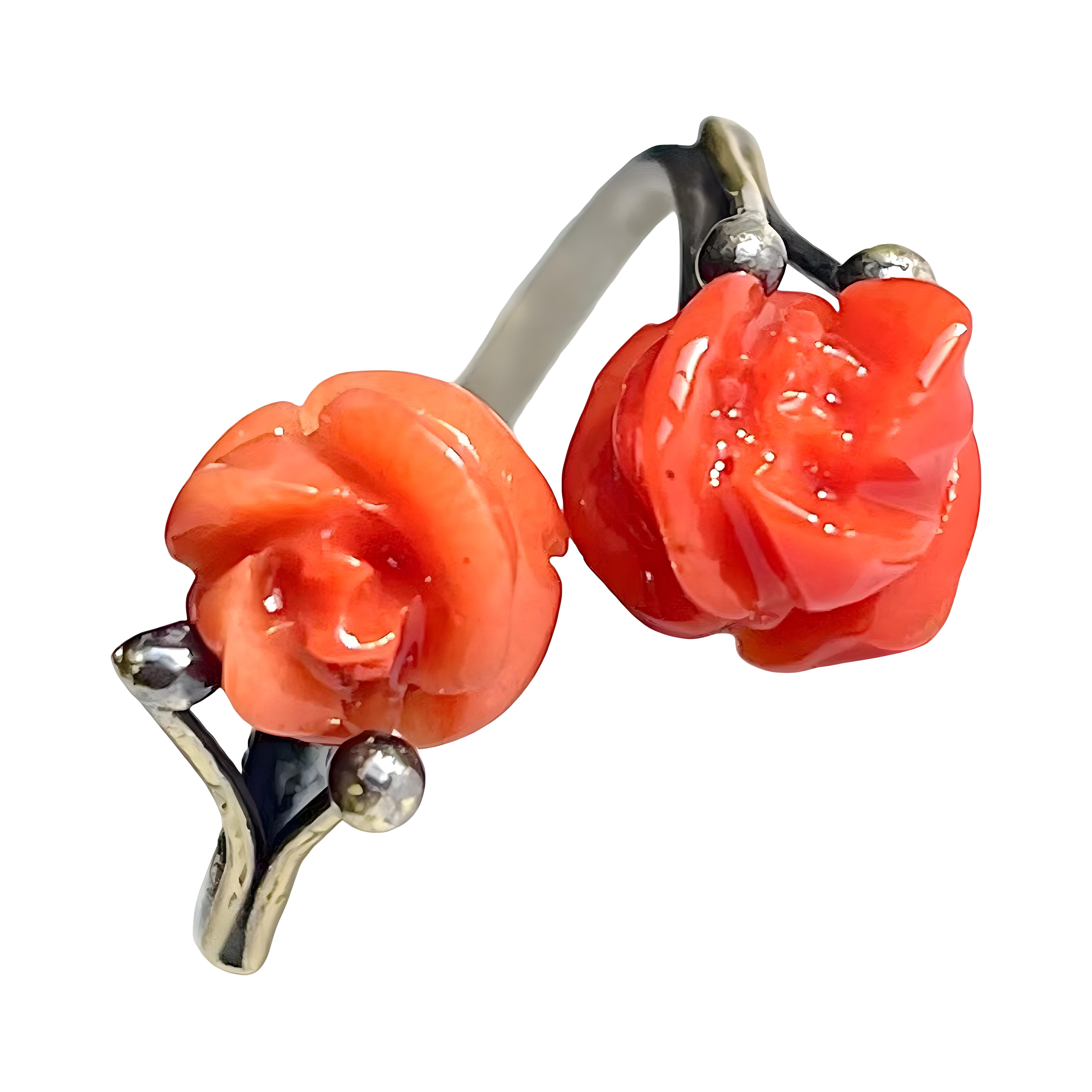 Superb antique Italian ring featuring carved red coral roses and 800 silver, in excellent condition. The ring has two coral roses and an adjustable band made of 800 silver, which allows it to fit different finger sizes. The coral is red in colour