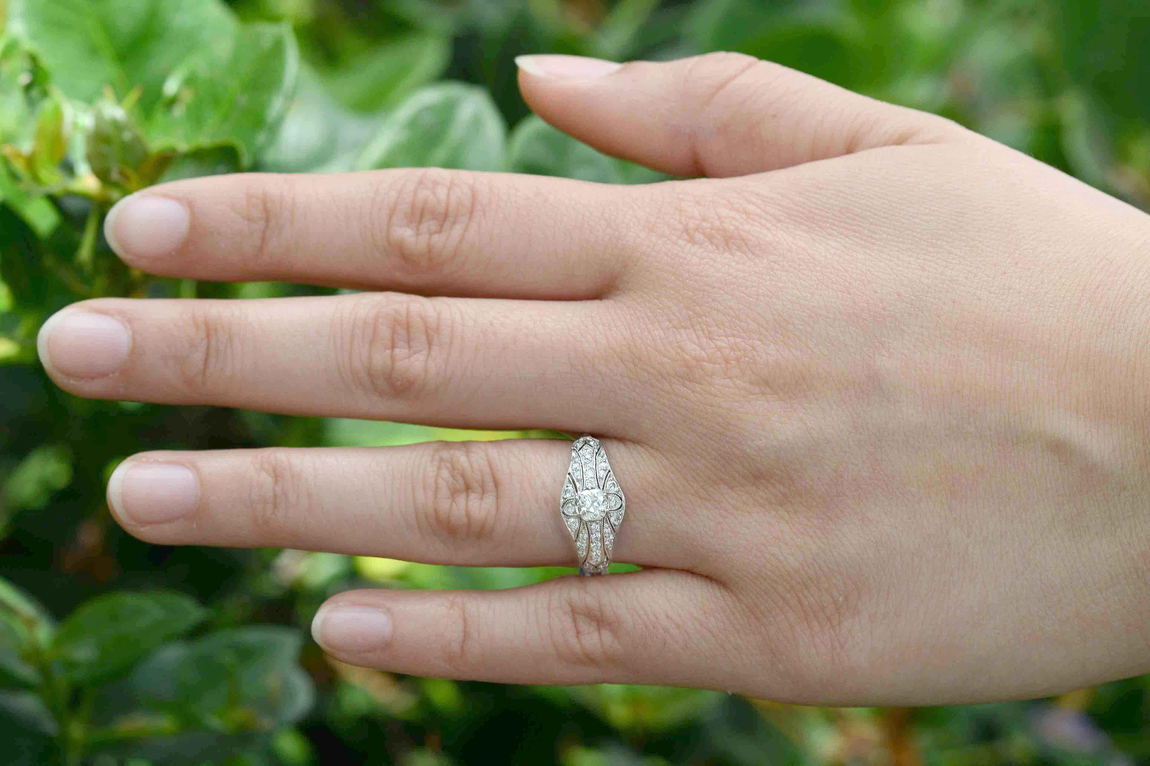 The elegance, romance and beauty of the Edwardian era shows through in this heirloom engagement ring. Meticulously crafted of platinum in a low setting and embellished with a sparkling, chunky old mine cut diamond supported by a lacy, filigree