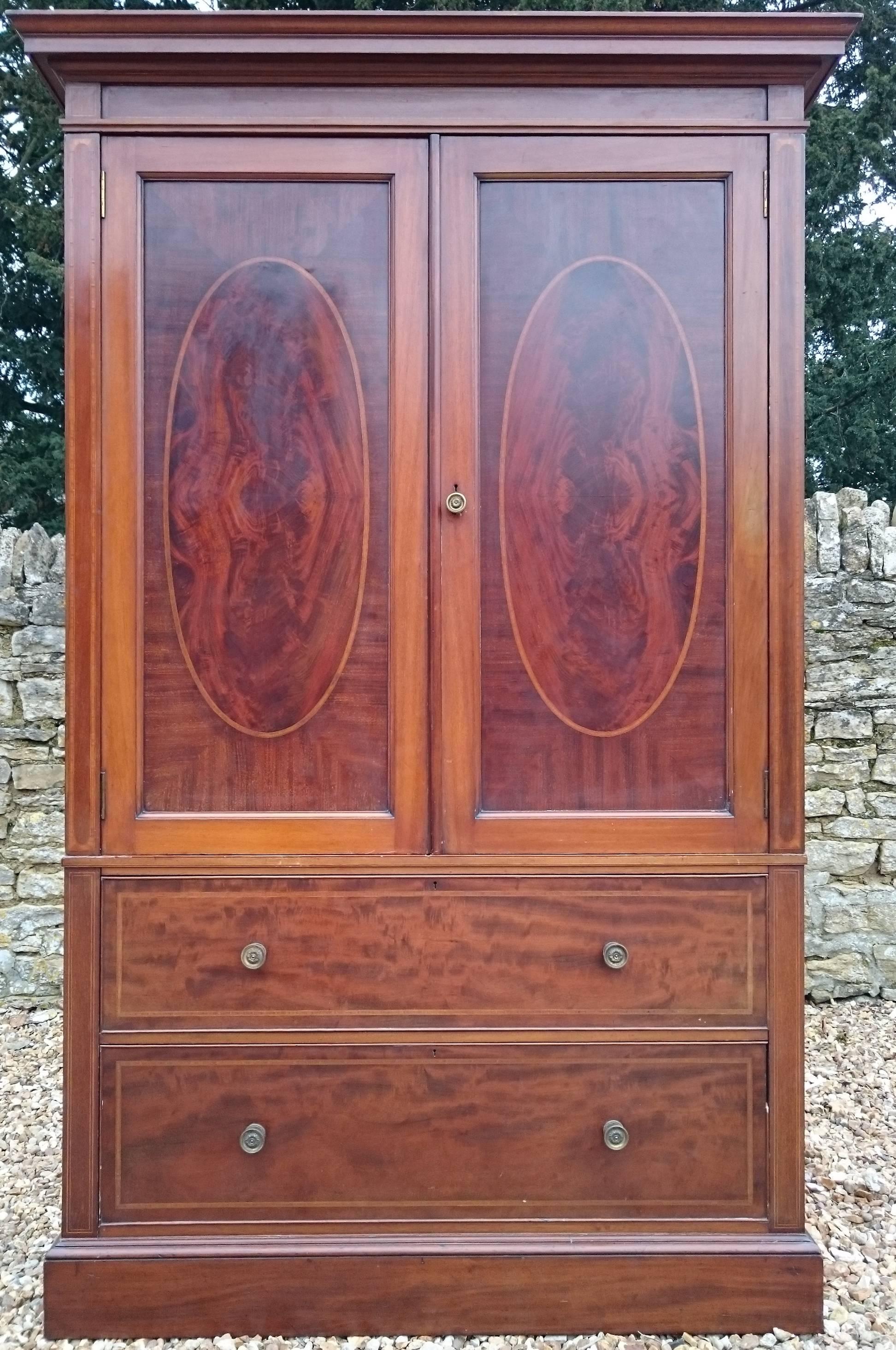 Antique mahogany linen press made by Gillow of Lancaster and London. This linen press is made of a very fine cut of fiddle back mahogany on the drawer fronts and with flame mahogany on the door fronts. It has solid mahogany drawer linings,