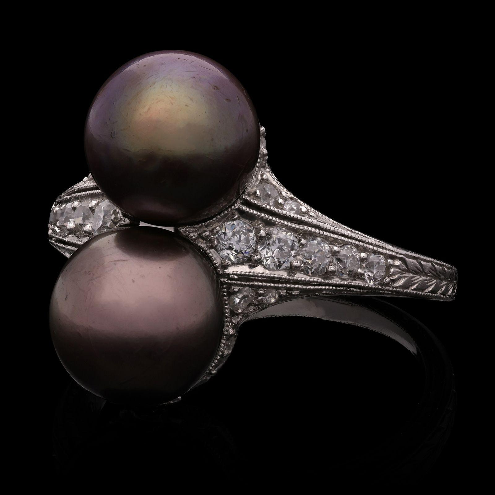 A beautiful Edwardian pearl and diamond ring by Gattle, c.1910, the ring vertically set to the front with two brownish-purple round natural saltwater pearls between tapered shoulders set with old cut diamonds all in millegrain settings to an