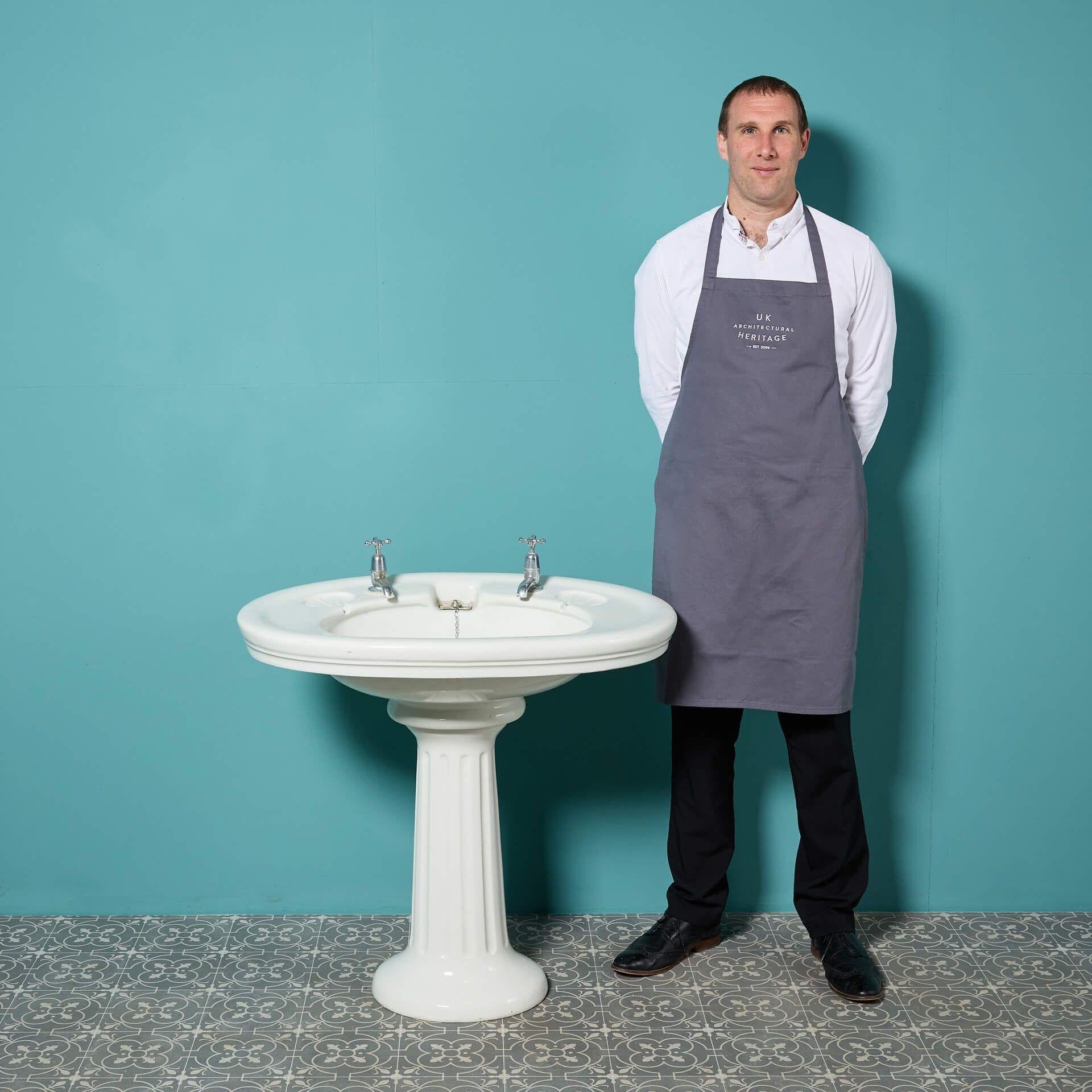 Un évier antique édouardien à piédestal avec un grand bassin ovale et un piédestal cannelé. Avec sa forme agréable et sa grande échelle, cet évier en porcelaine est un lavabo élégant pour une salle de bains vintage ou un vestiaire élégant de style