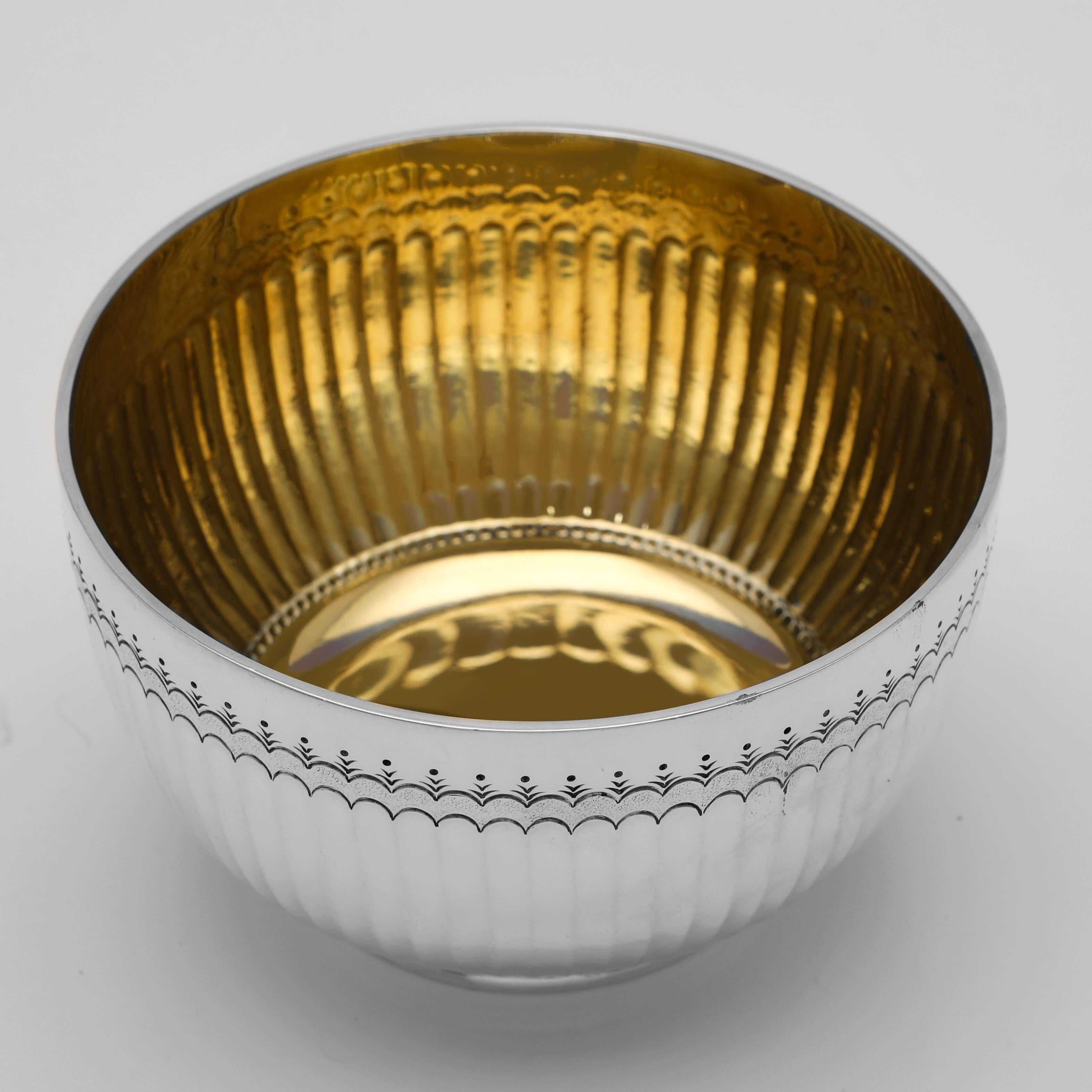 Hallmarked in London in 1902 by F. B. Thomas & Co., this attractive, Edwardian, Antique Sterling Silver Bowl, features sunken fluting, a band of engraved decoration near the rim, and a gilt interior. 

The bowl measures 2.75