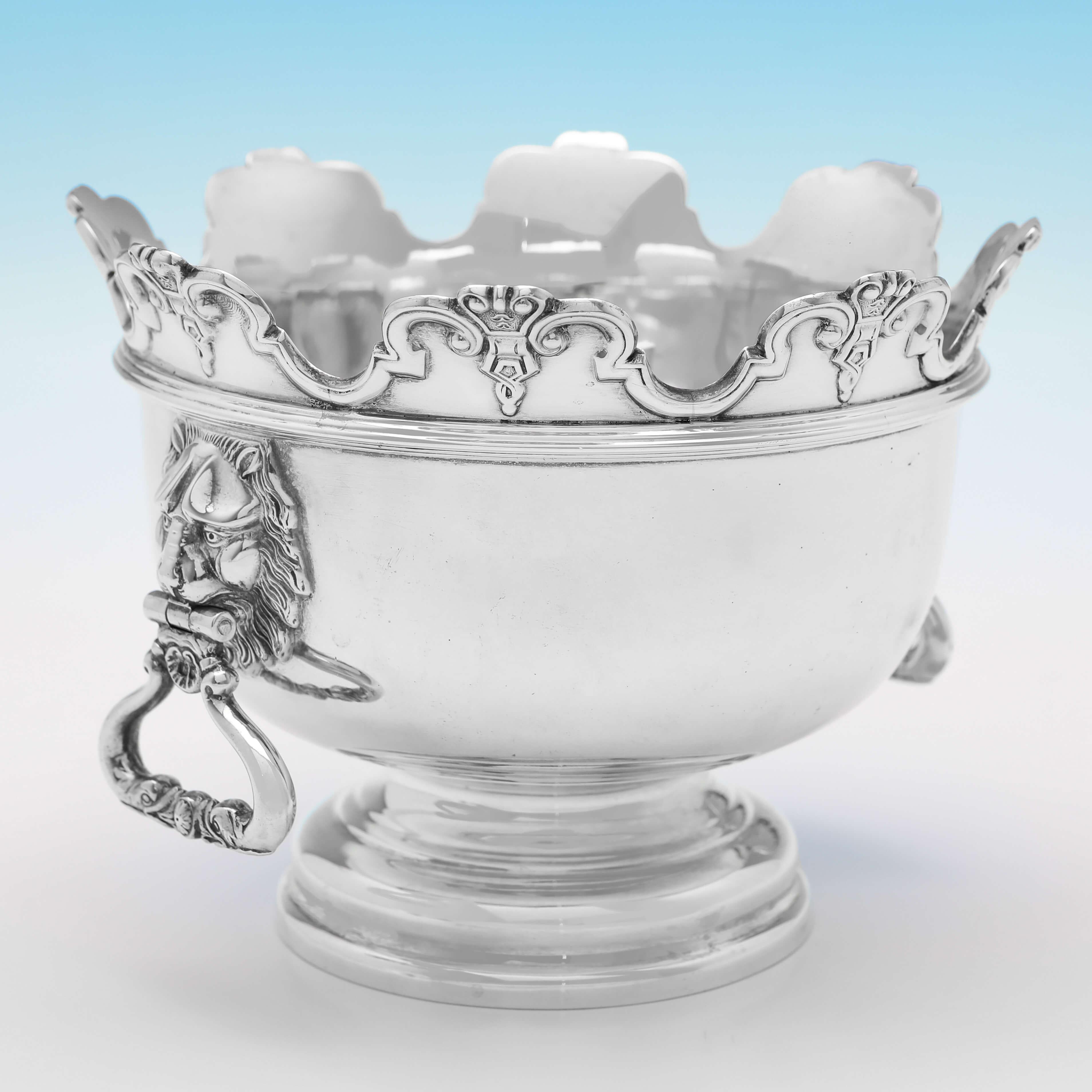 Hallmarked in London in 1905 by Hawksworth Eyres & Co., this charming, Edwardian, Antique Sterling Silver Bowl, is based on the 'Monteith' style. The bowl stands on a reed detailed pedestal base and features a decorative shaped edge, and lion mask