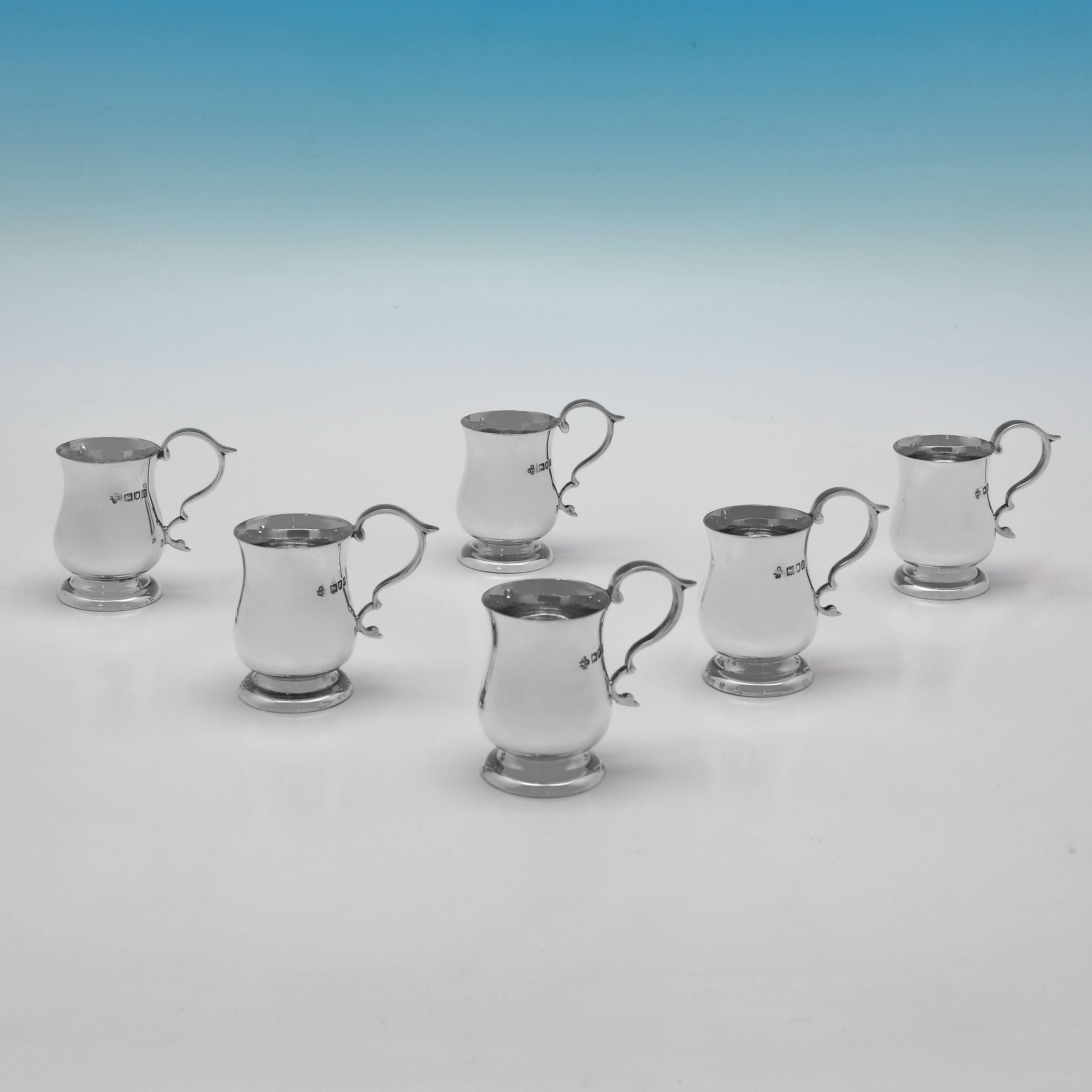 Hallmarked in London in 1909 by Horace Woodward & Co., this handsome set of 6 antique sterling silver tot cups, are modelled to look like traditional baluster mugs, and are presented in their original box. 

Each tot cup measures 2