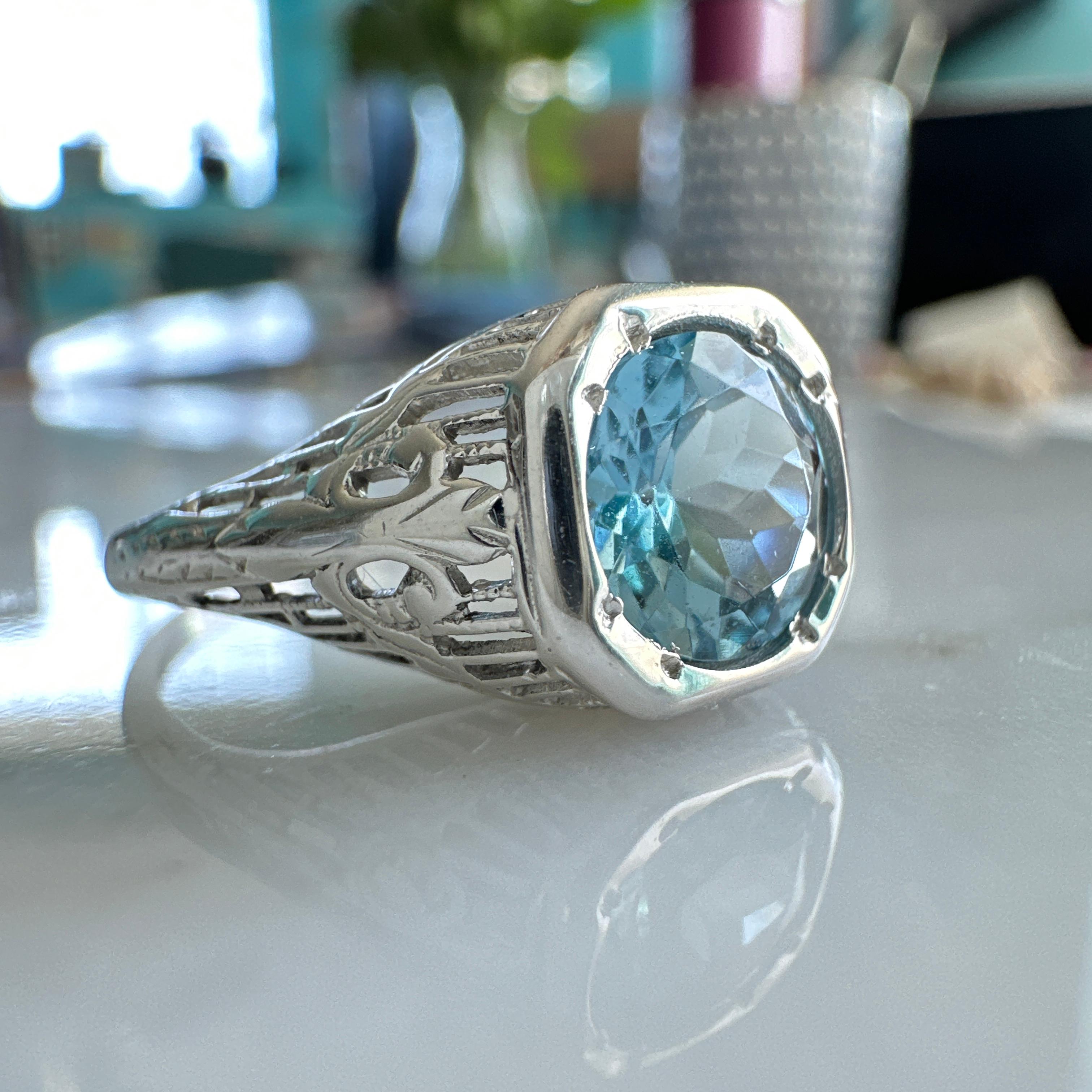 Details: 
Beautiful Edwardian Aquamarine 18K white gold filigree ring. This ring is very sweet, with delicately detailed filigree with tiny French fleur-de-lis. The aquamarine stone is light in color, but not super pale with a beautiful blue with a