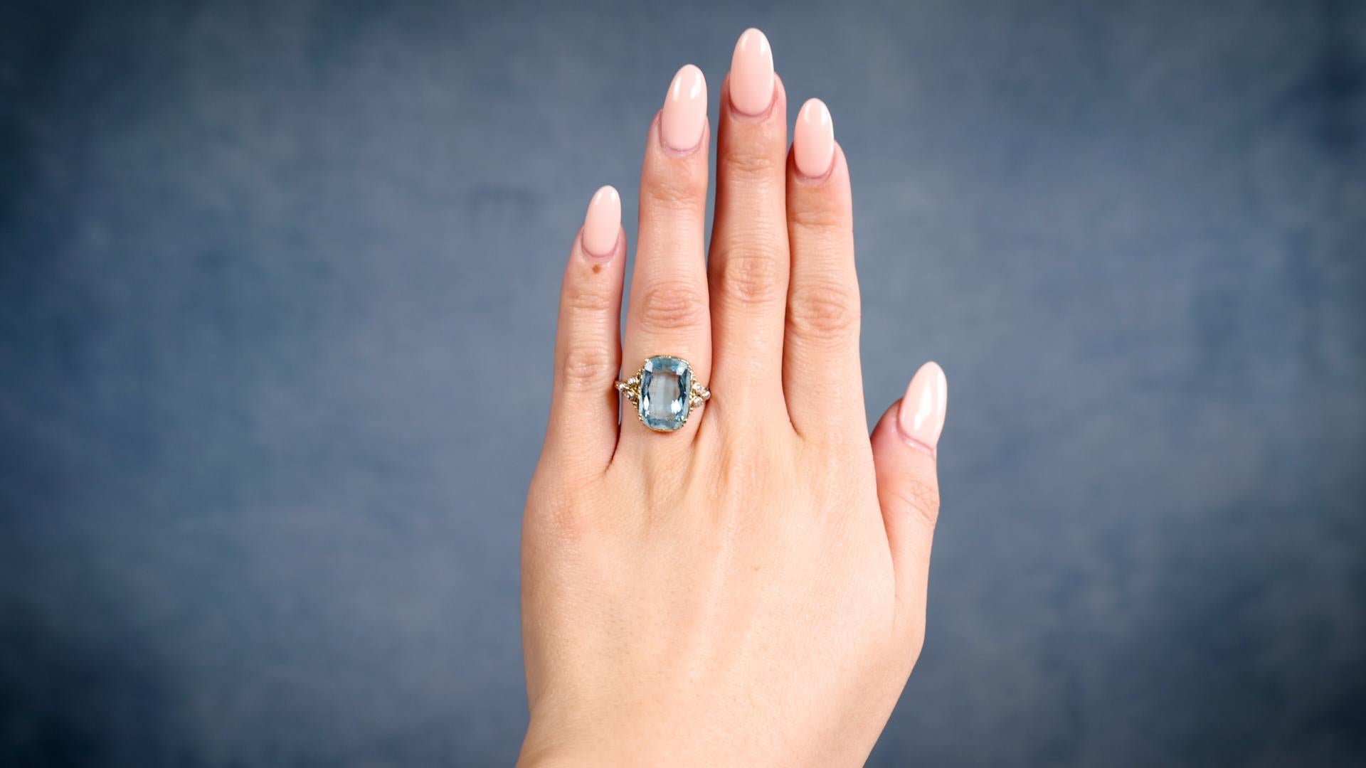 One Edwardian Aquamarine Diamond 14k Yellow Gold Silver Ring. Featuring one cushion cut aquamarine weighing approximately 4.75 carats. Accented by six senaille cut diamonds. Crafted in 14 karat yellow gold with diamonds set in silver. Circa 1900.