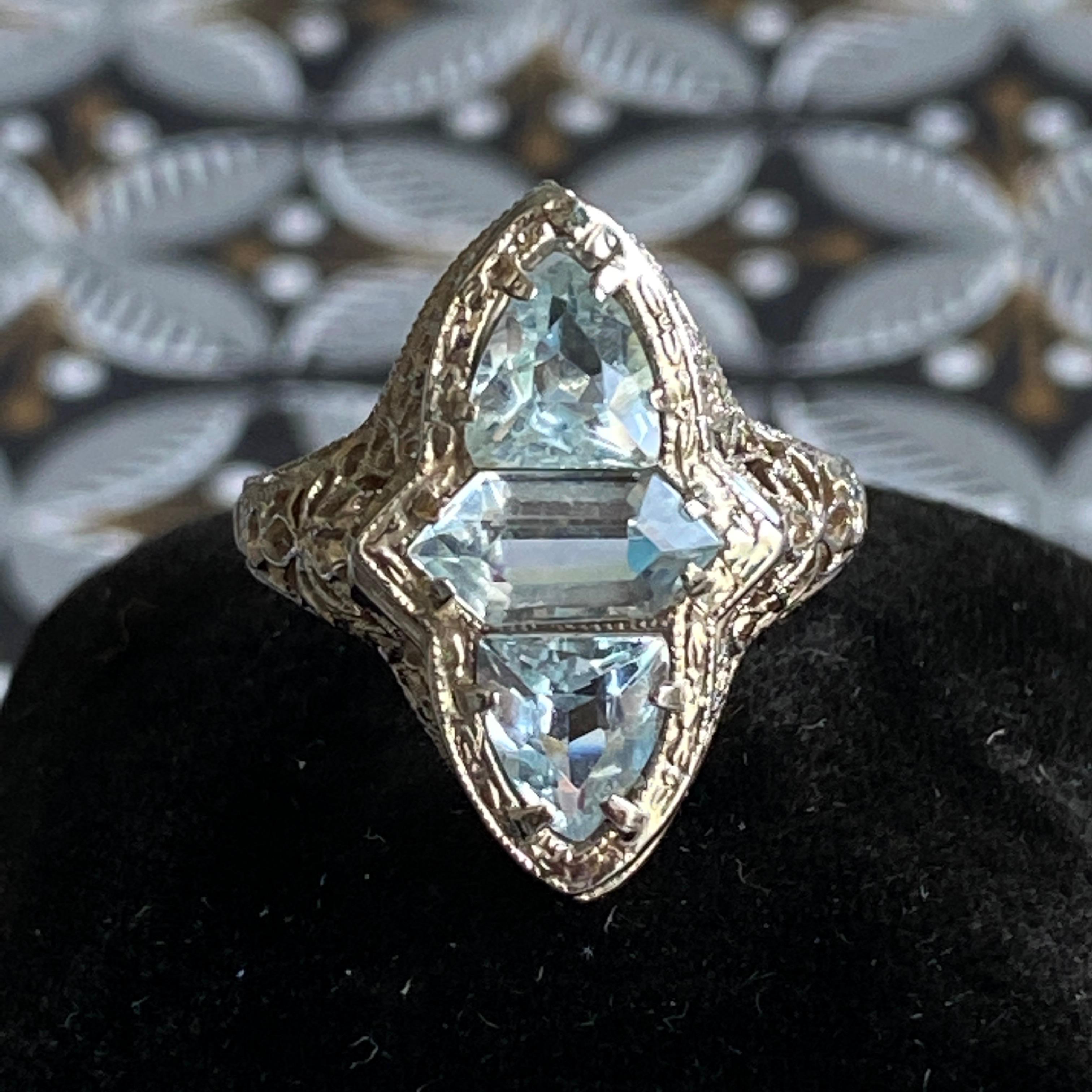 Details:
Stunning Edwardian 14K white gold floral patterned filigree details and three gorgeous aquamarine stones! The two triangle aquamarines measure 5mm x 6mm; and center stone measures 4mm x 8mm, with a classic beautiful blue color. The front of