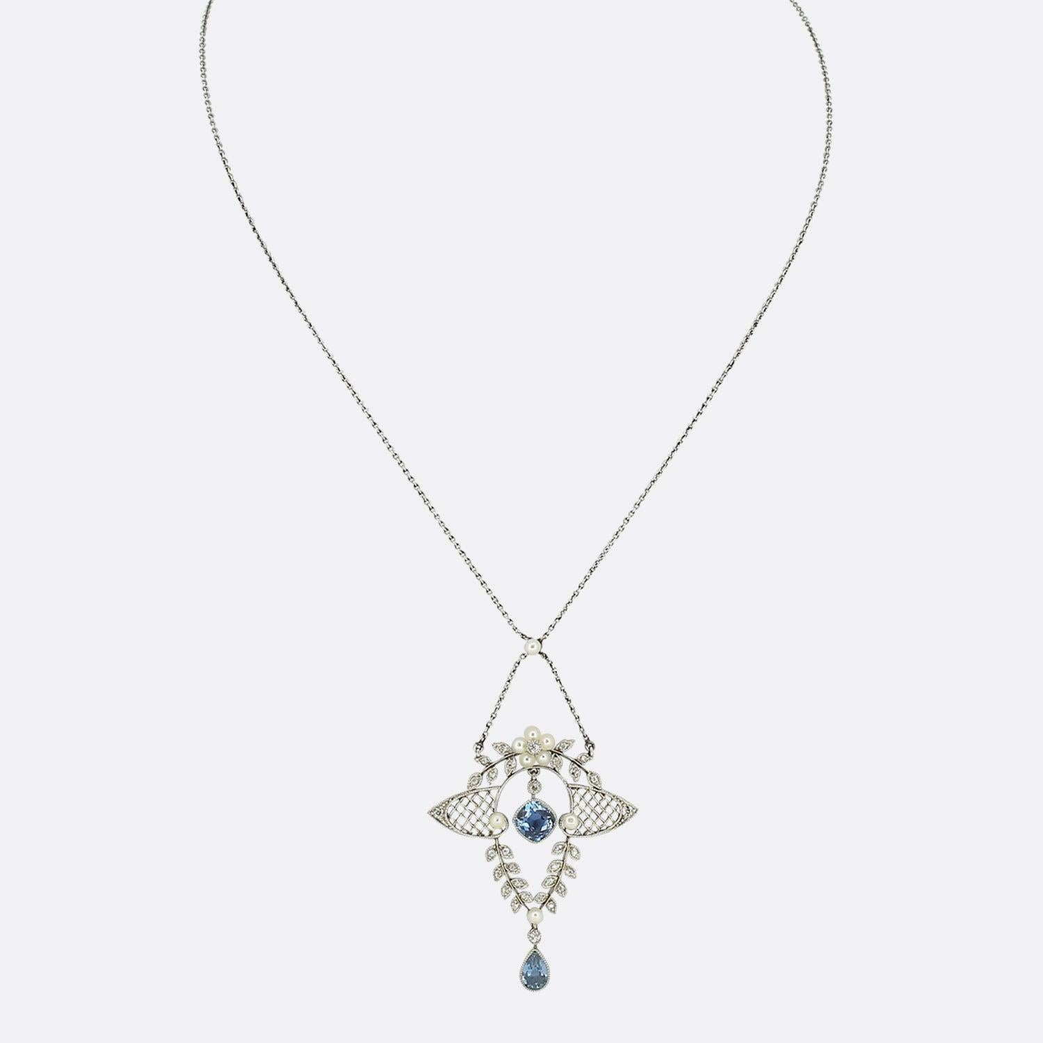 Il s'agit d'un élégant collier à pendentifs en aigue-marine et diamants, datant de l'époque Elegardienne. Le collier se compose d'une aigue-marine centrale en forme de coussin, entourée de perles naturelles et de diamants de taille ancienne dans une