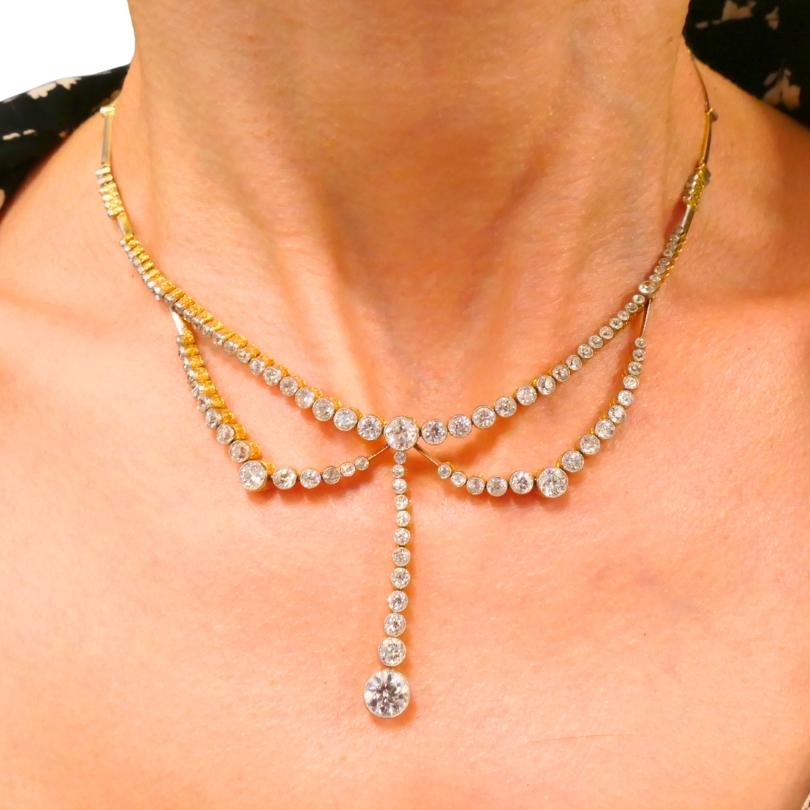 Este collar de finales de la época eduardiana y principios del Art Déco está elaborado en oro de 18 quilates y platino y engastado con diamantes de talla vieja europea. El collar presenta un llamativo diseño en dos partes. La parte superior está