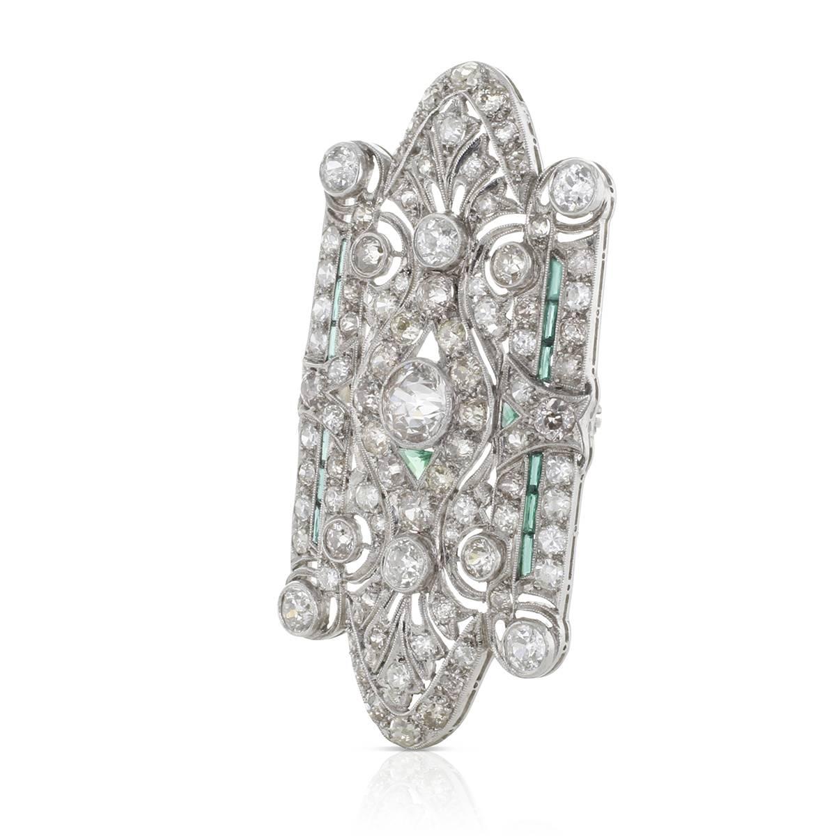 A 2 1/8 inch long oblique brooch expertly hand fabricated in platinum, circa 1930s, is set with vintage old minor cut round diamonds. Large diamond of over 1 carat sits proud in the center bezel adorned by small round diamond sparklers, all accented
