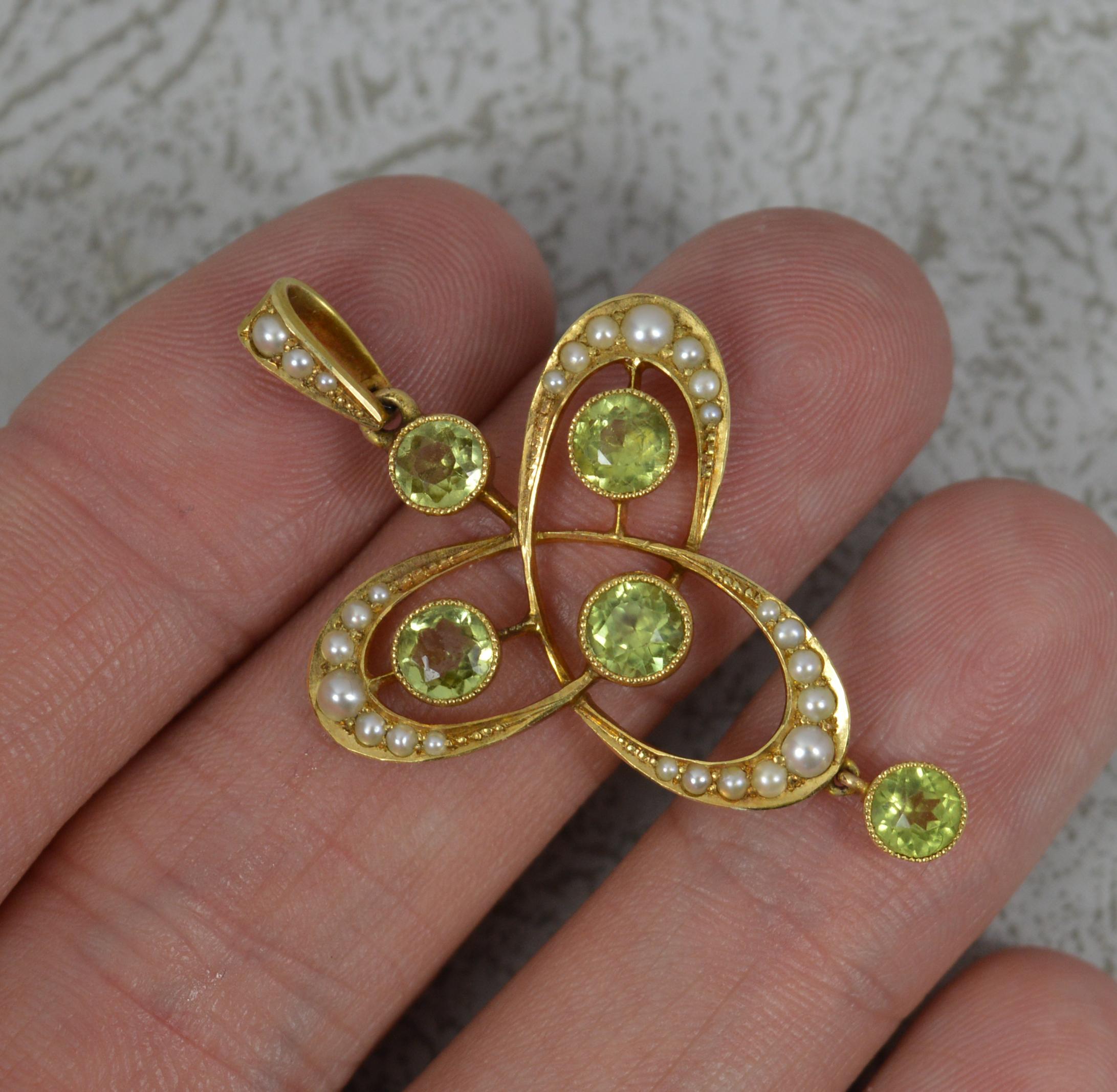 A stunning Edwardian period pendant, circa 1905.
Solid 15 carat yellow gold example.
A flowing trefoil type shape. Set with five round peridot stones in fine grain bezel settings and set with many seed pearls surrounding.

CONDITION ; Excellent for