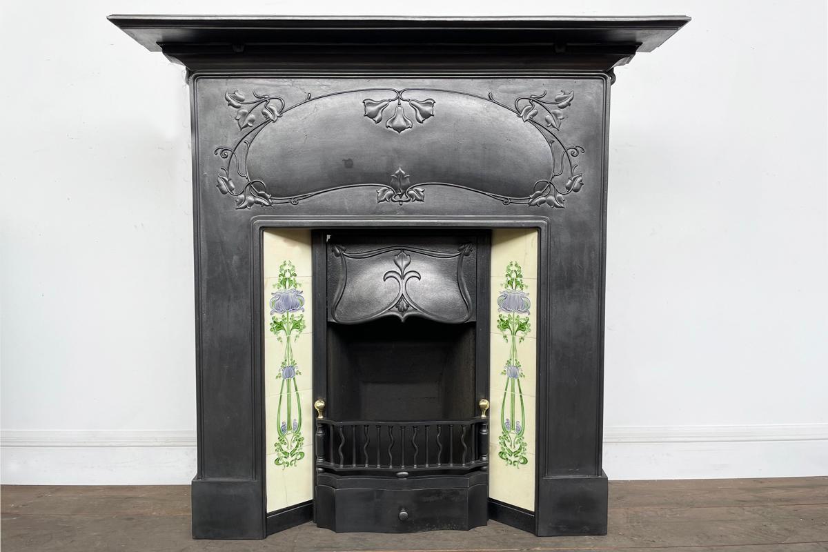 A good example of a large antique Edwardian Art Nouveau cast iron combination fireplace. Circa 1905. With finely cast deep frieze above an equally well cast canopy. The canopy has a small loss to the top left corner. The grate benefits from polished