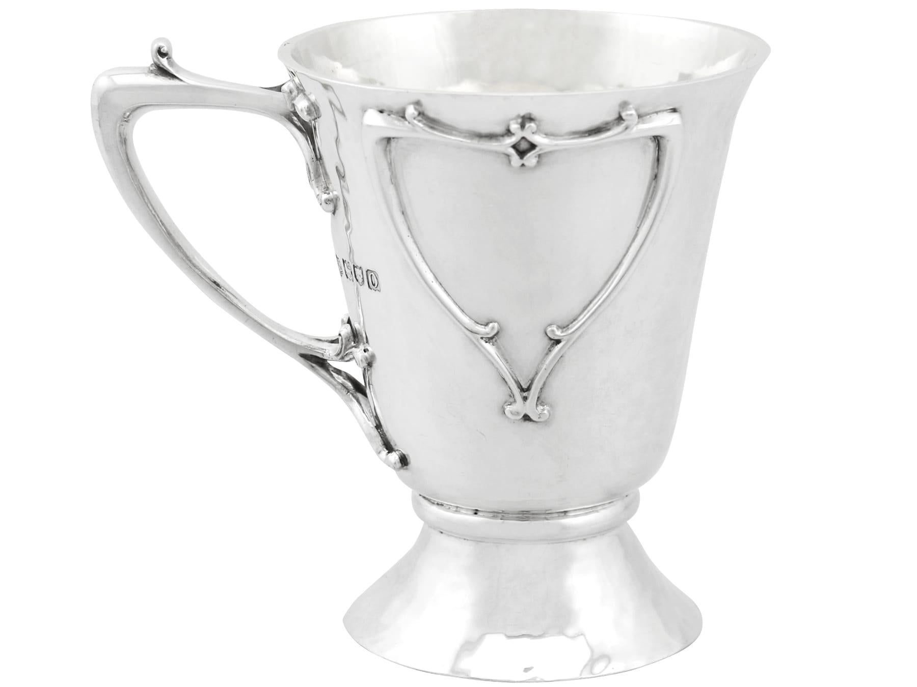 An exceptional, fine and impressive antique Edwardian English sterling silver christening mug made in the Art Nouveau style, boxed; an addition to our religious silverware collection.

This exceptional antique Edwardian sterling silver christening