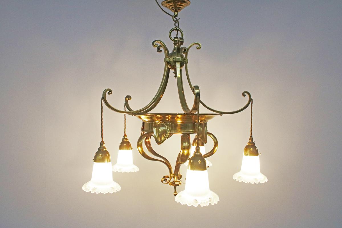 Edwardian Arts & Crafts brass five branch electrolier ceiling light in the style of Birmingham guild of Handicraft, circa 1900. Complemented by replacement frosted glass shades. We currently have a pair of these lights available.
Fully rewired and