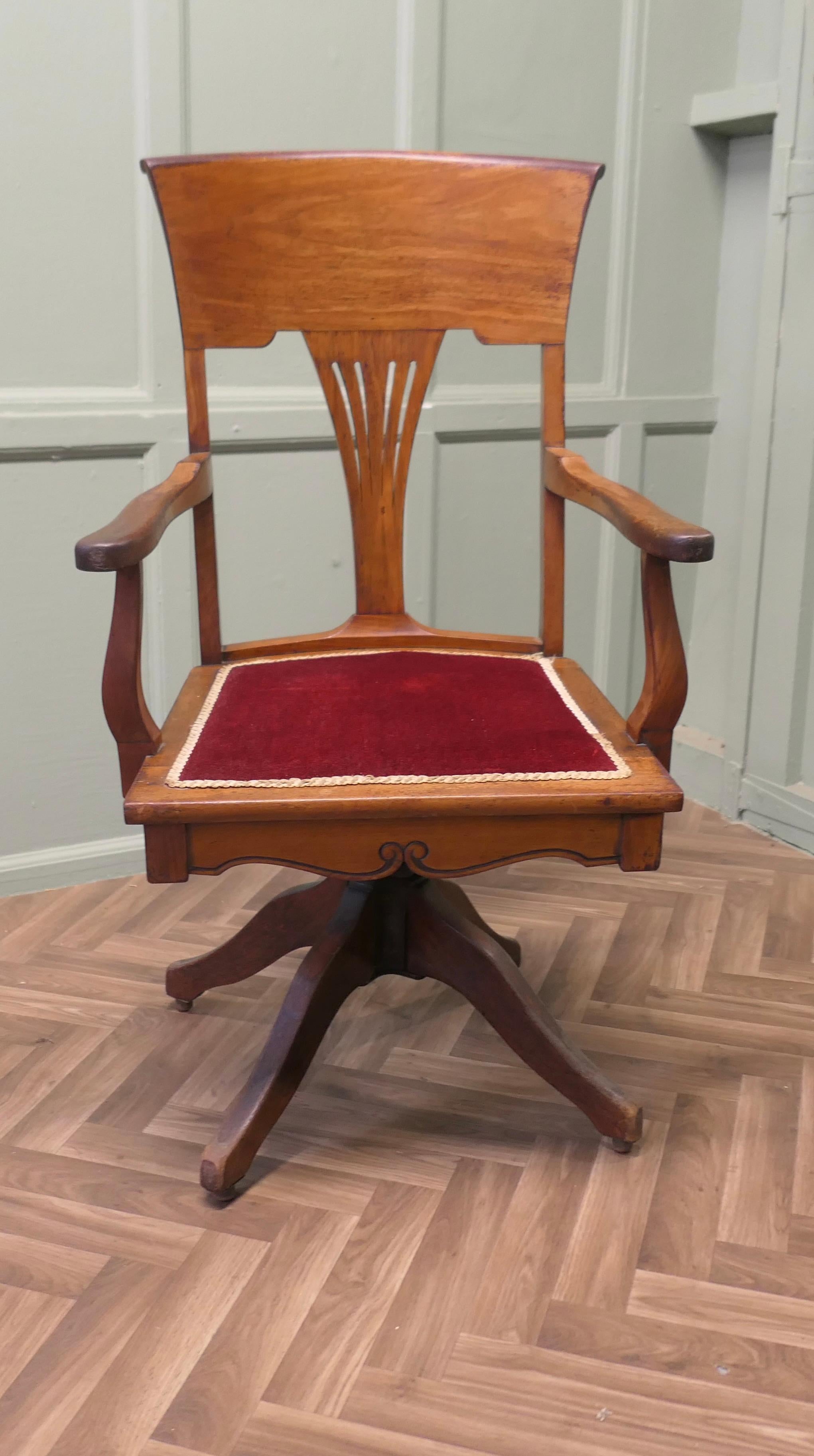 Edwardian Arts and Crafts Walnut Desk or Office Chair  

The Chair has an attractive high curving back with a fan shape pierced splat and a wide curved top rail, the seat is upholstered with old Wine coloured velvet
This Stylish chair swivels easily