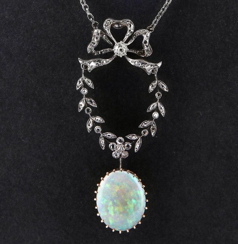 Aston Estate Jewelry Presents:

An Edwardian period Australian opal bow and garland necklace. Featuring a traditional diamond set bow and garland motif set throughout with old rose cut diamonds, and centered with a prong set old mine cut diamond.