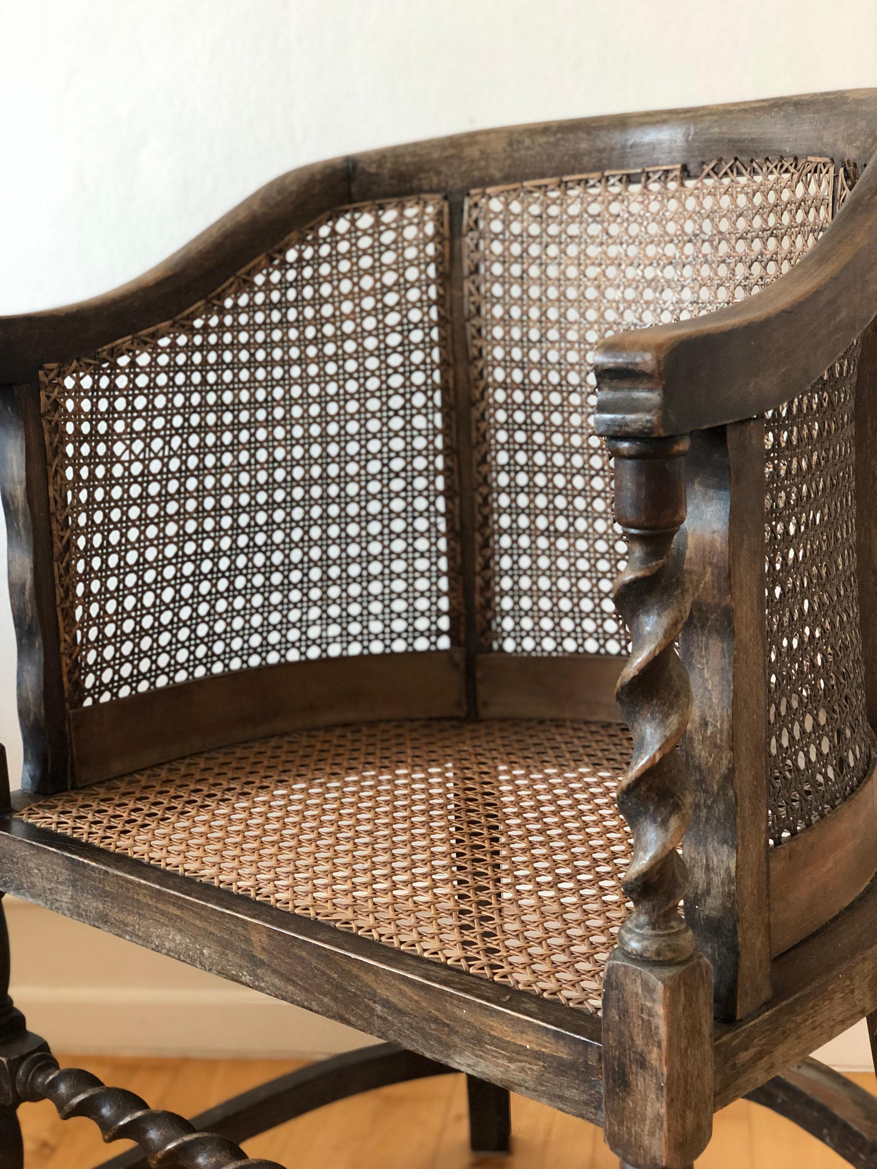 Esta silla eduardiana, fabricada en haya maciza a principios del siglo XIX, es a la vez robusta e intemporal. Con asiento, laterales y respaldo de caña, proporciona comodidad y apoyo fiables. El diseño se complementa con patas de torsión de cebada y