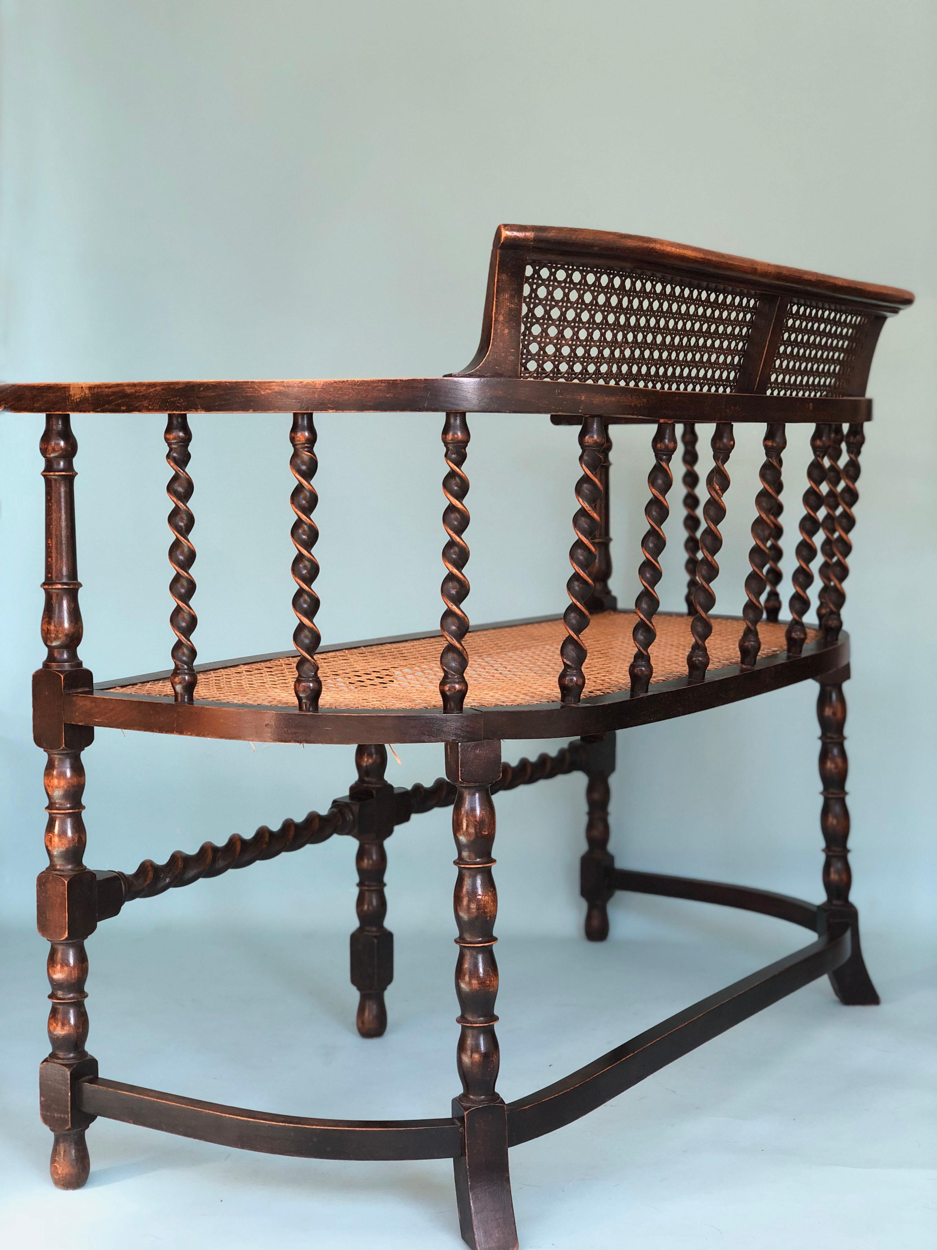 An English Edwardian bench with cane, barley twist supports and bobbin turned legs from the early 20th century. The beech wood chair and cane are in very good condition. The cane seat is from a later period. The cane in the back is original.


A