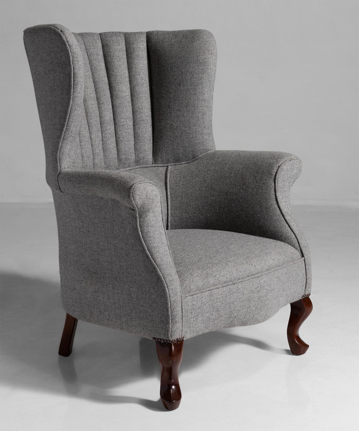Edwardian barrel back armchair, England, circa 1910.

Newly upholstered in a wool herringbone tweed on mahogany legs.