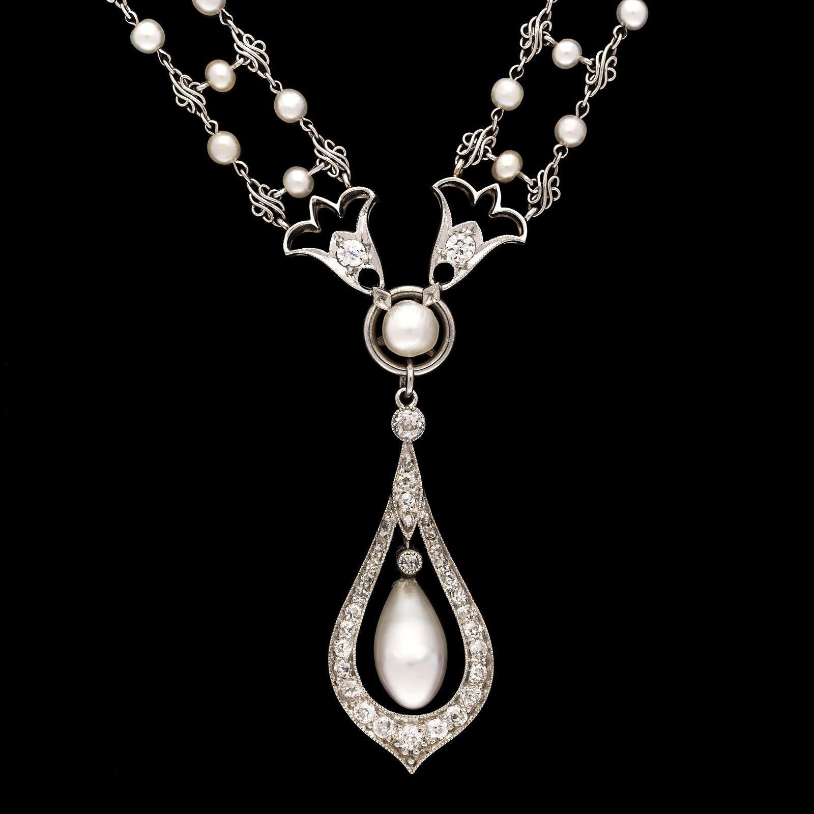 A beautiful antique Edwardian pearl and diamond sautoir necklace c.1910, the necklace formed of a double row of seed pearls interspersed with platinum triple scroll links and joined together by single seed pearls forming a loosely woven effect,