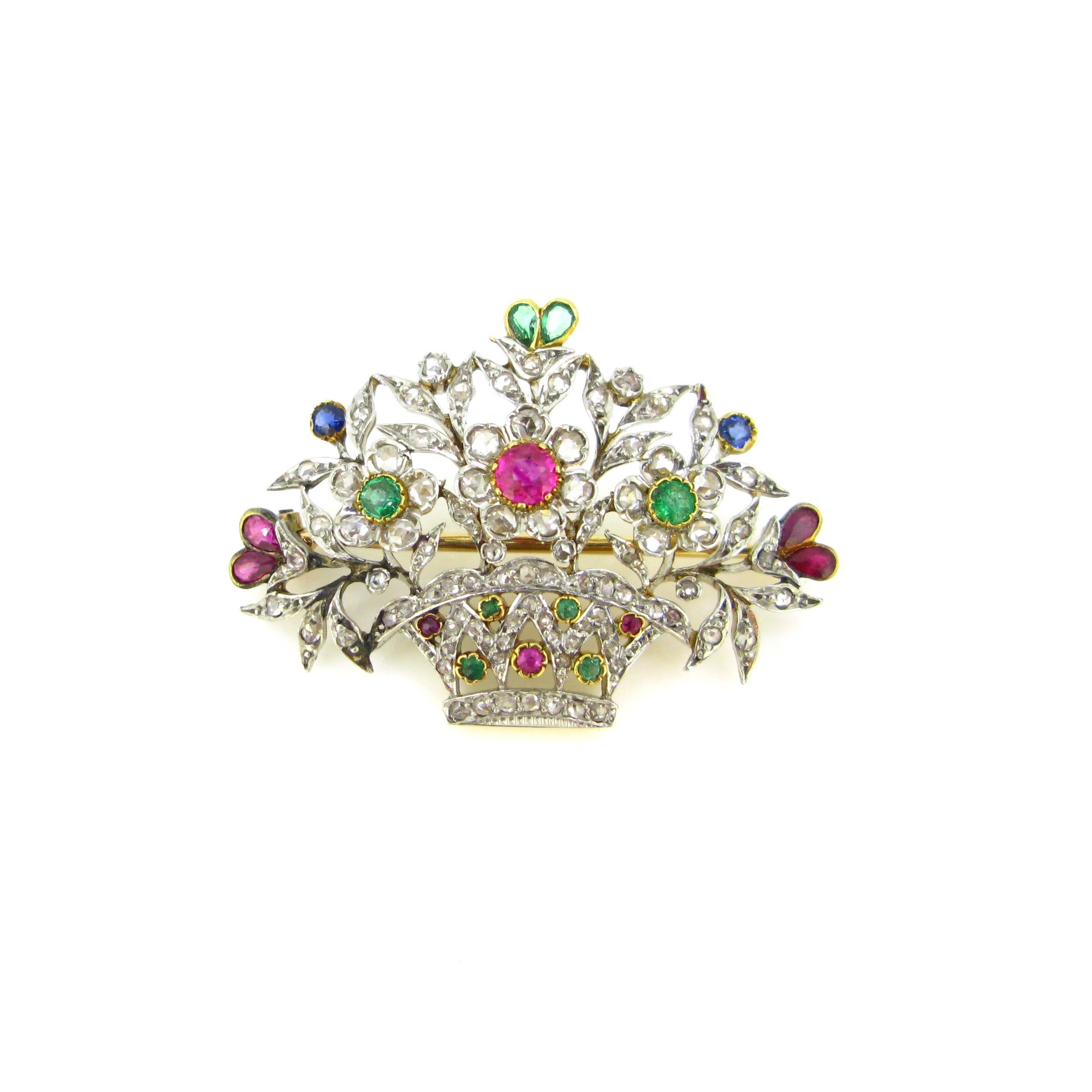 This brooch features blossom flowers on a basket. The brooch is set with natural rubies, emeralds and sapphires. The petals are adorned with rose cut diamonds. We can call this kind of brooch Giardinetto that means small garden in Italian. It is not