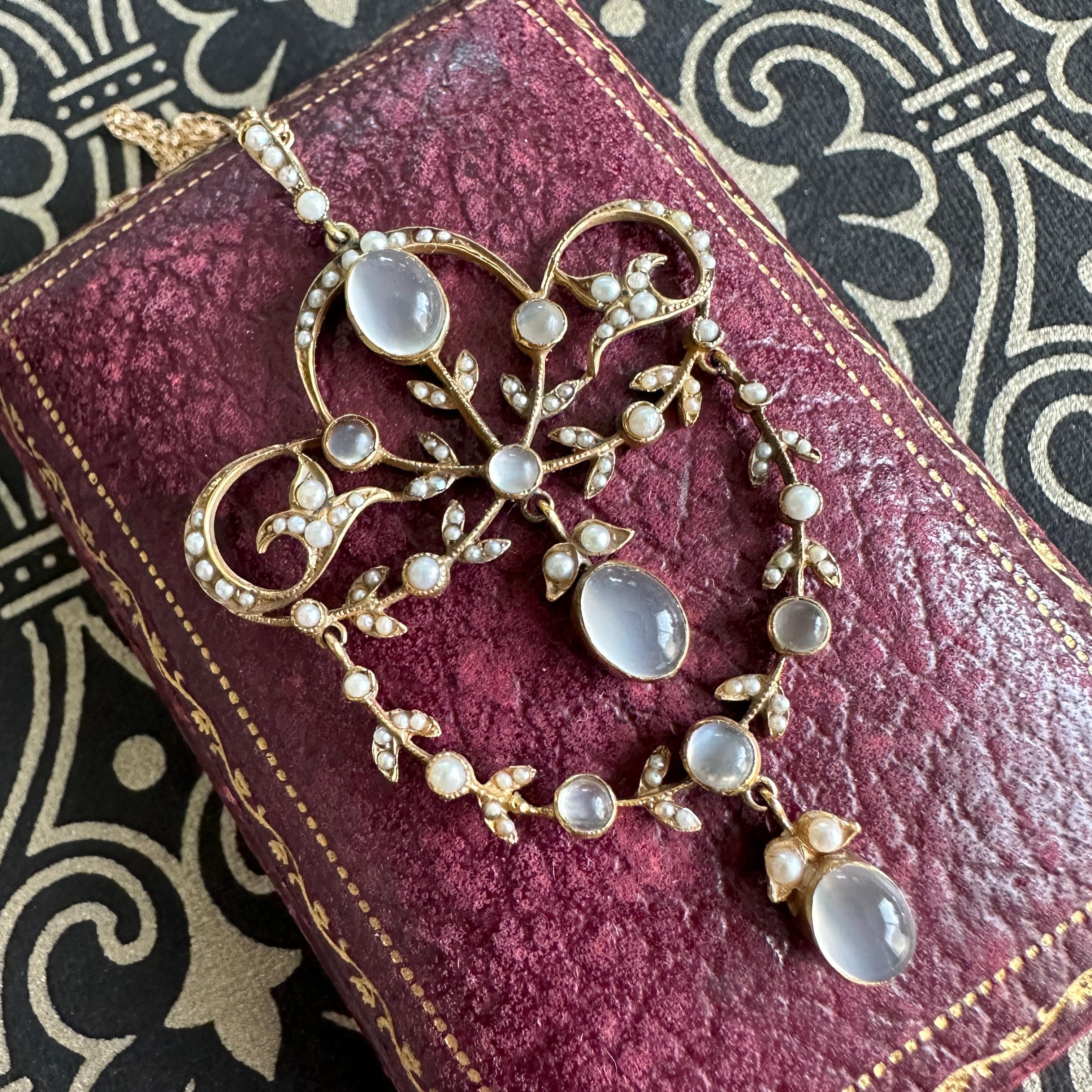 Details:
Edwardian Belle Époque moonstone and seed pearl pendant in 15K yellow gold. This Edwardian piece dates from the early 1900's. There are three large oval grey cats eye moonstones, with six smaller round moonstones adorning this pendant. The