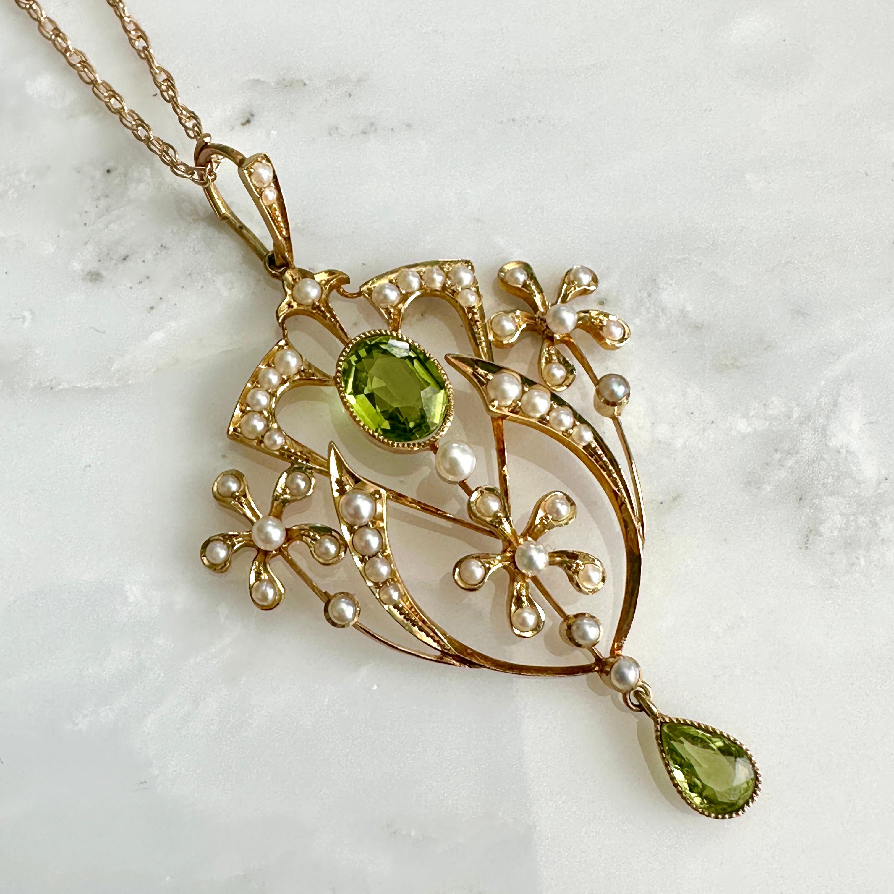 Details:
Edwardian Belle Époque Peridot and seed pearl pendant necklace set in 15K yellow gold. This lovely pendant is delicate, and bold at the same time. The two peridots are a vibrant bright apple green color, the larger center one measures 8mm x