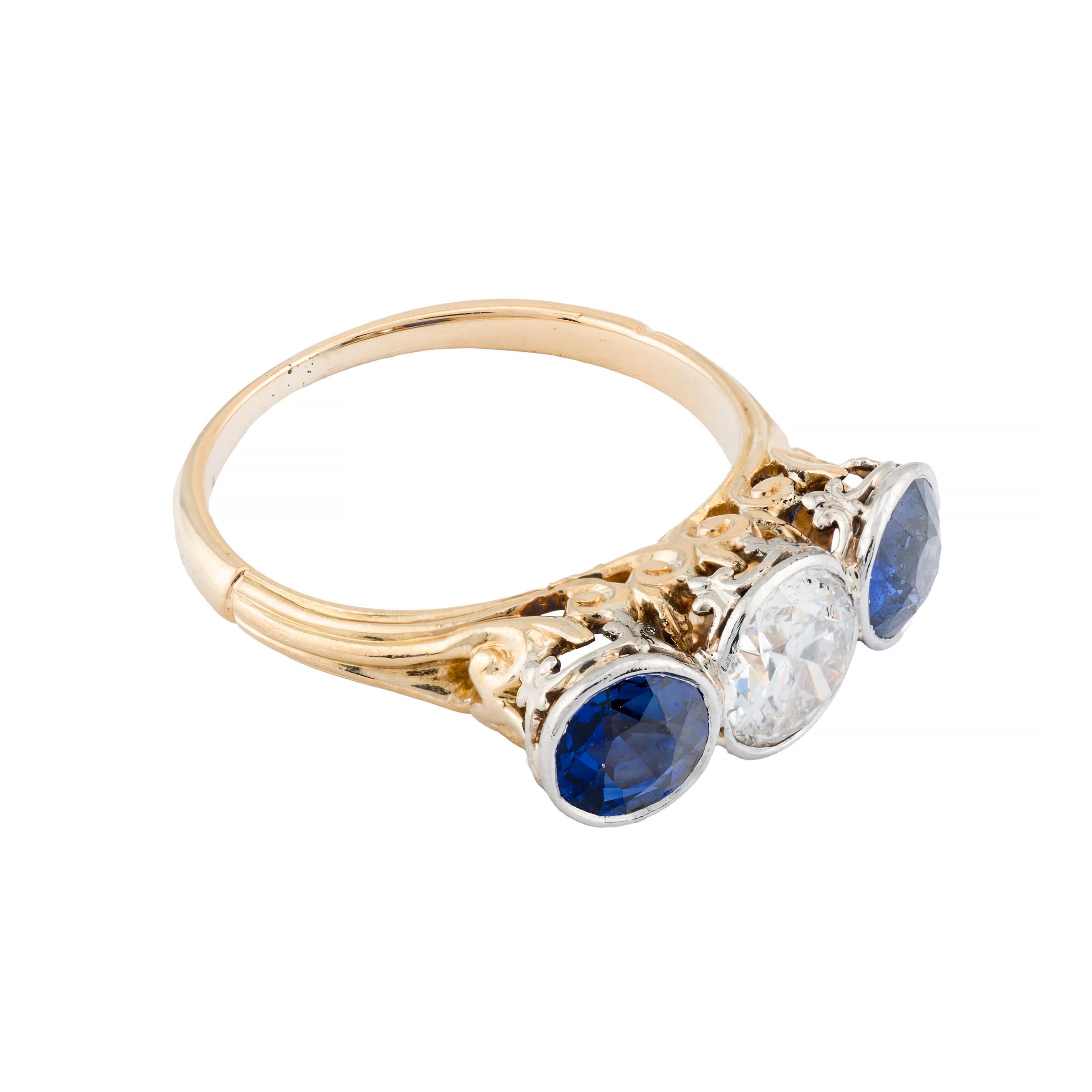 Aston Estate Jewelry Presents:

An exquisite  engagement ring showcasing a 0.75-carat European-cut diamond, with a clarity of SI2 and a color grade of I. The diamond is elegantly flanked by two European-cut blue sapphires, totaling 1.20 carats. The