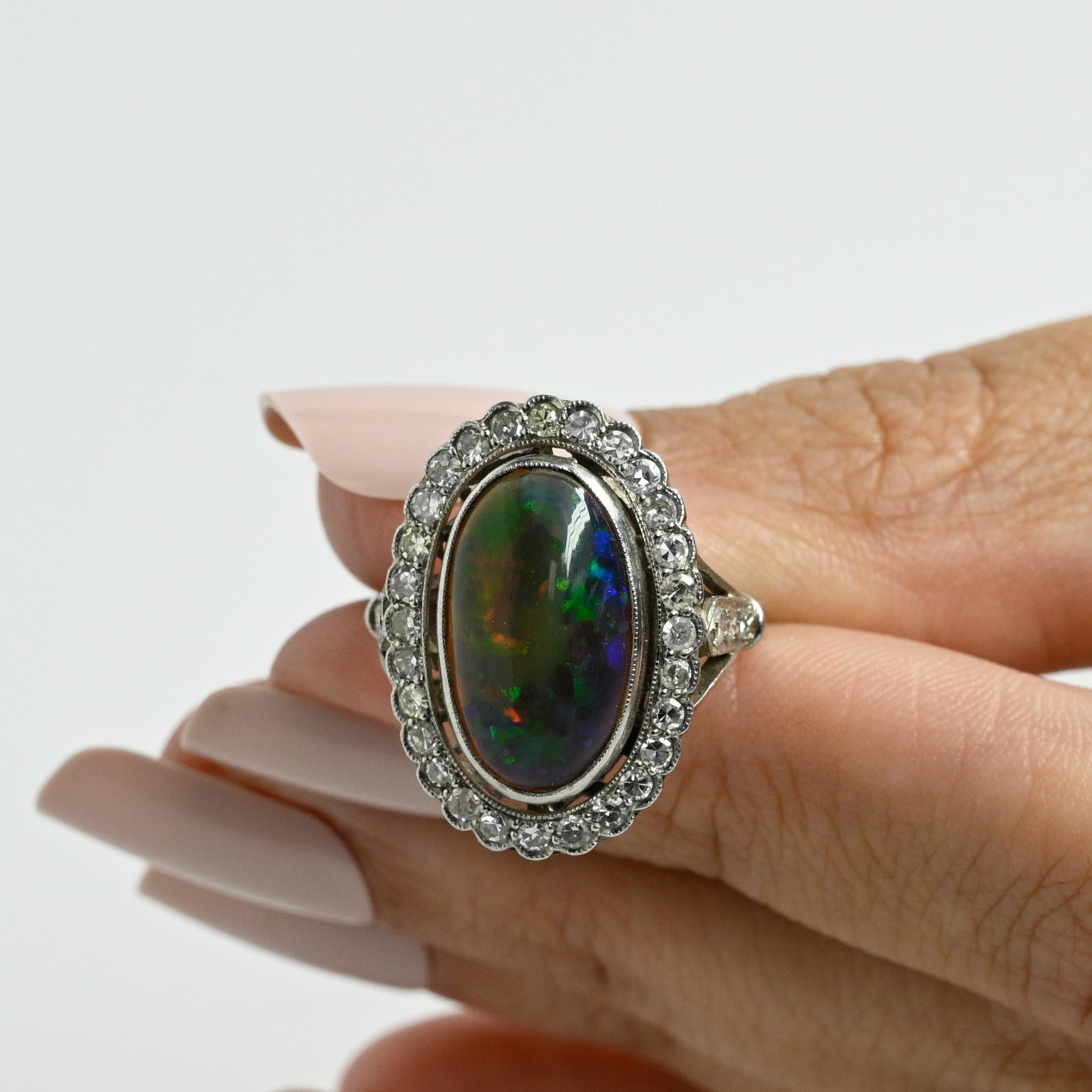 Lassen Sie sich von der exquisiten Schönheit dieses edwardianischen Opal-Cabochon-Rings verzaubern. Er präsentiert einen atemberaubenden 6,19-karätigen Opal mit einem faszinierenden Harlekin-Muster. Dieser handgefertigte Platinring besticht durch