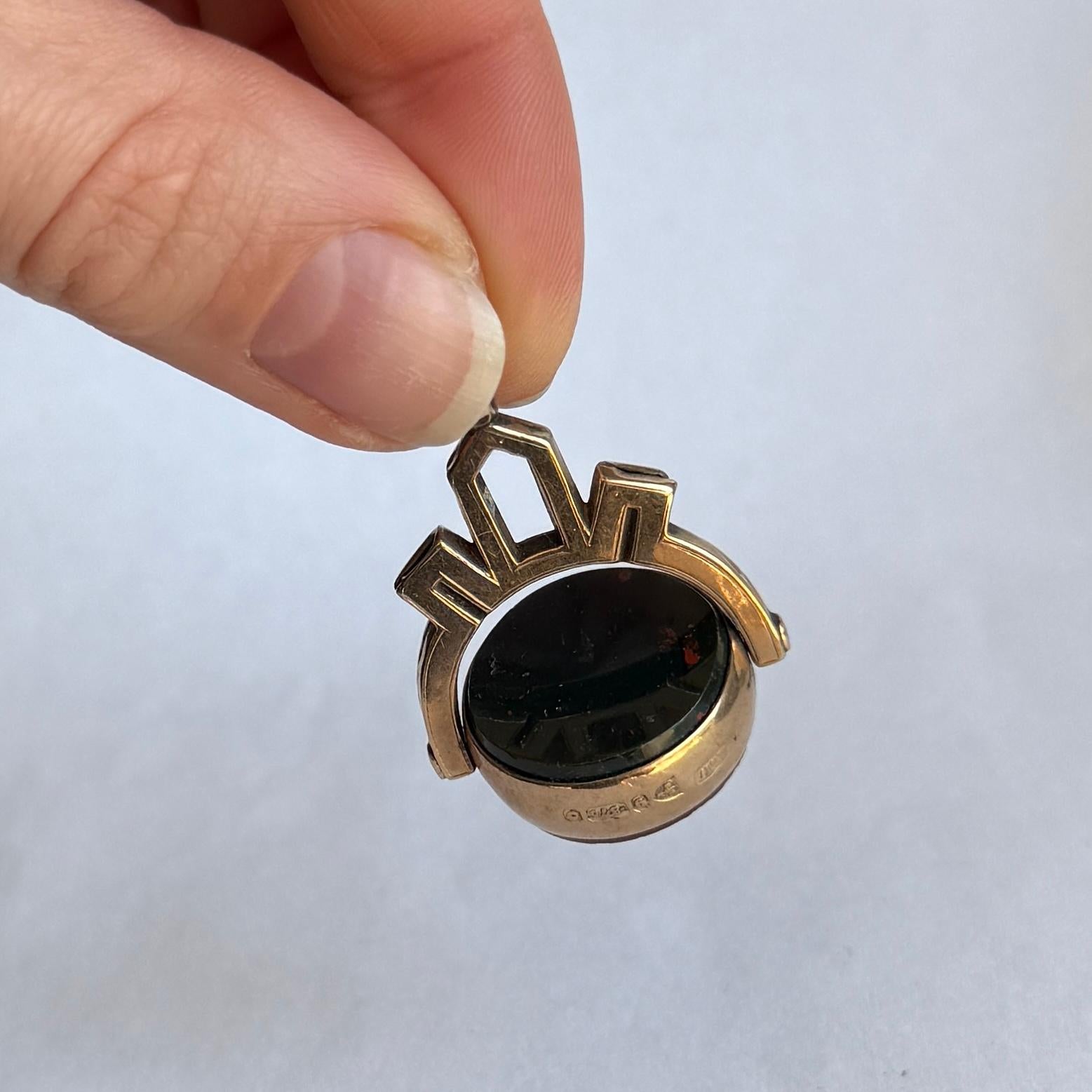 Questo classico portachiavi in oro 9ct contiene una corniola e una pietra sanguigna che ruotano! Le lavorazioni in oro sopra le pietre sono ornate e ricordano le maglie di una catena. Completamente marchiato Chester 1900.

Diametro della pietra: 19